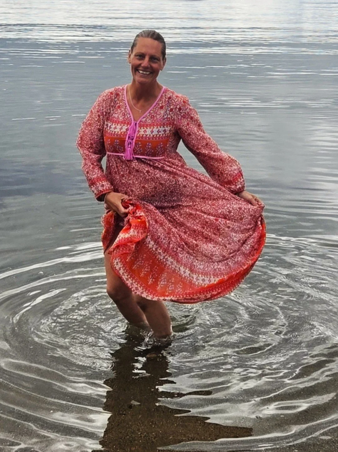 Sønni Røhr danser i vannet med rød kjole