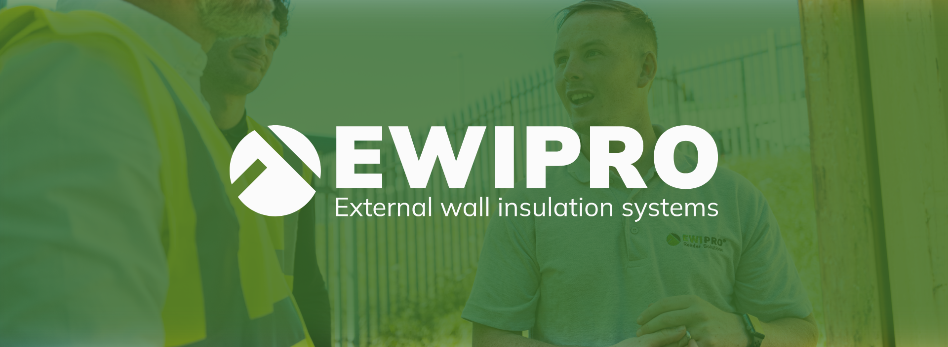 Three men in safety vests and a polo shirt with the EWIPRO logo talking outside near a fence, discussing wall insulation.