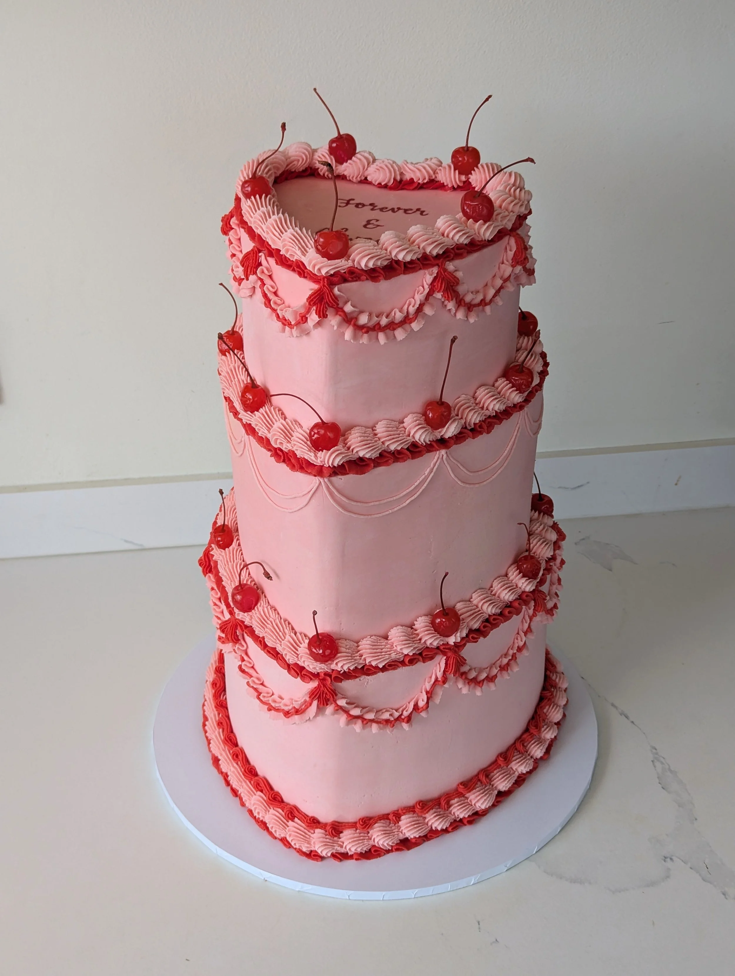 A showstopping three tier pink wedding cake with Lambeth piping and cherries. 