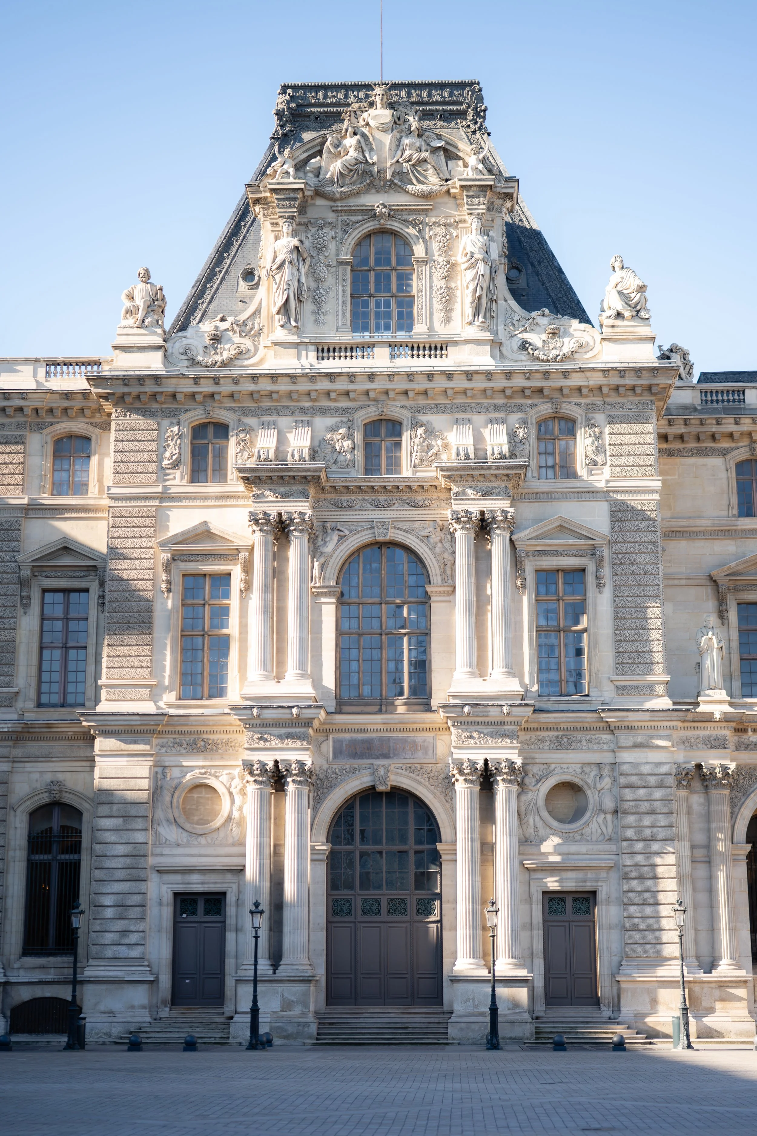 Facade of an ornate historic building with detailed sculptures, columns, and decorative elements.