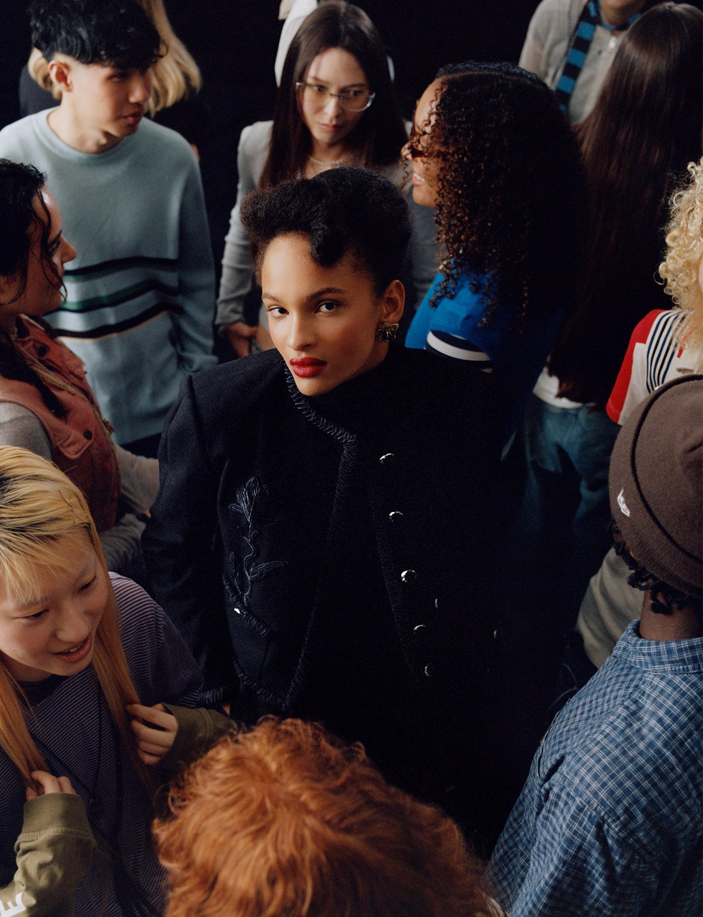 A diverse group of people gathered closely together, engaging in conversation and interaction.