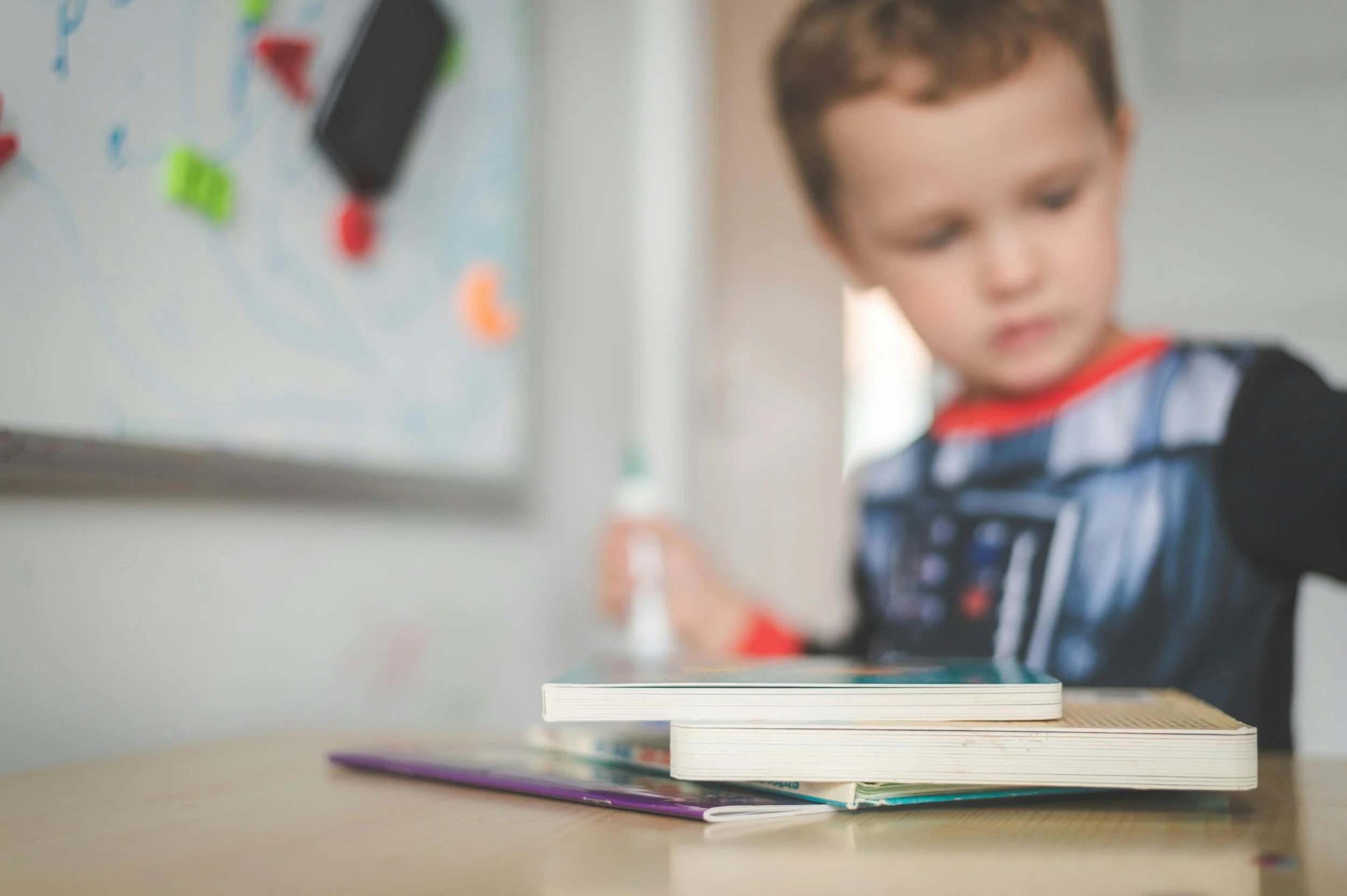 Primary-age child beside a stack of books.