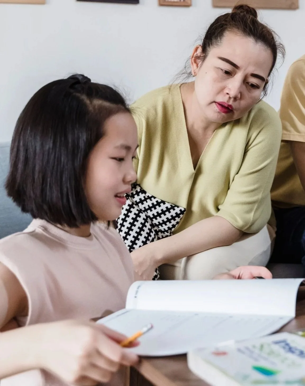 Adult and child reading a book together.