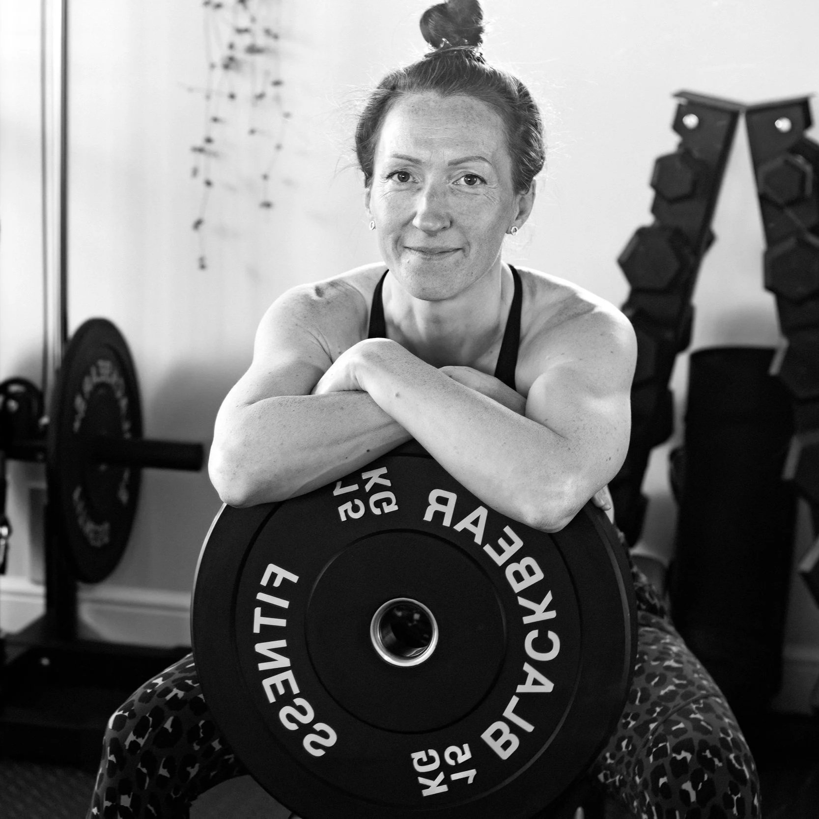 Friendly personal trainer in a fully equipped home gym