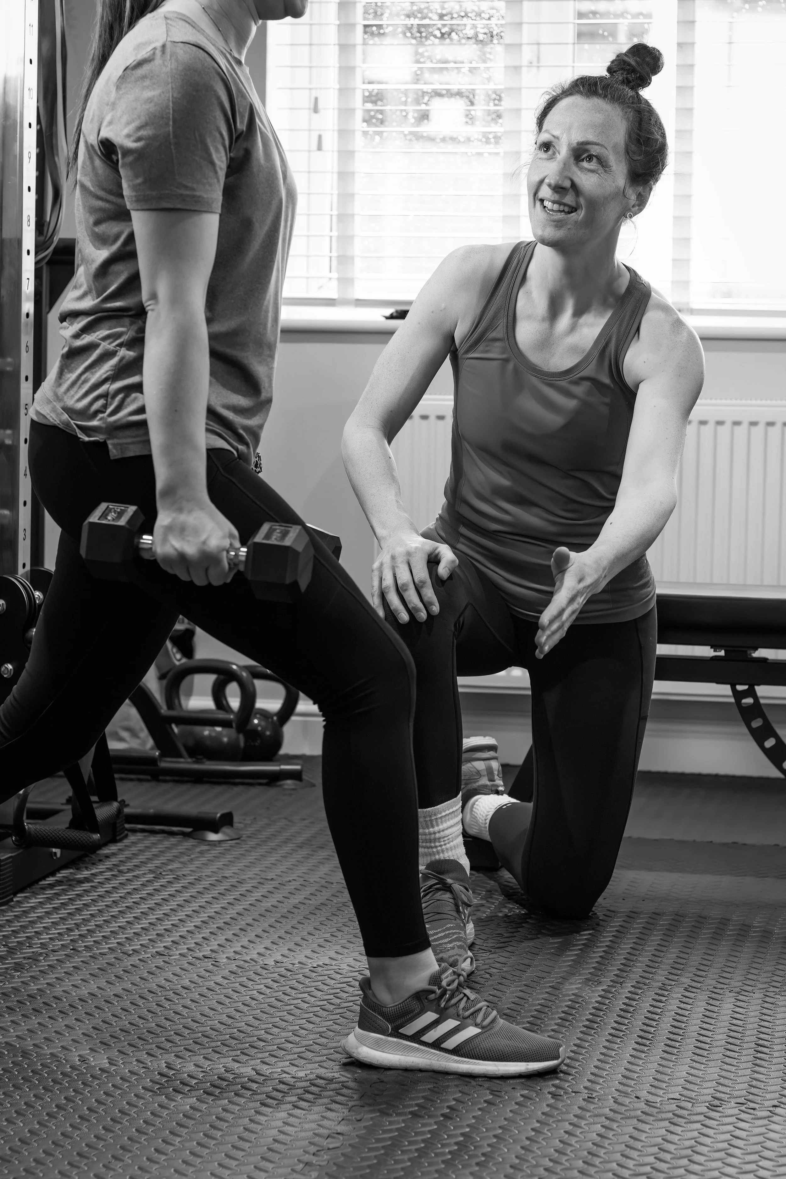 Woman performing dumbbell lunges during a personal training session