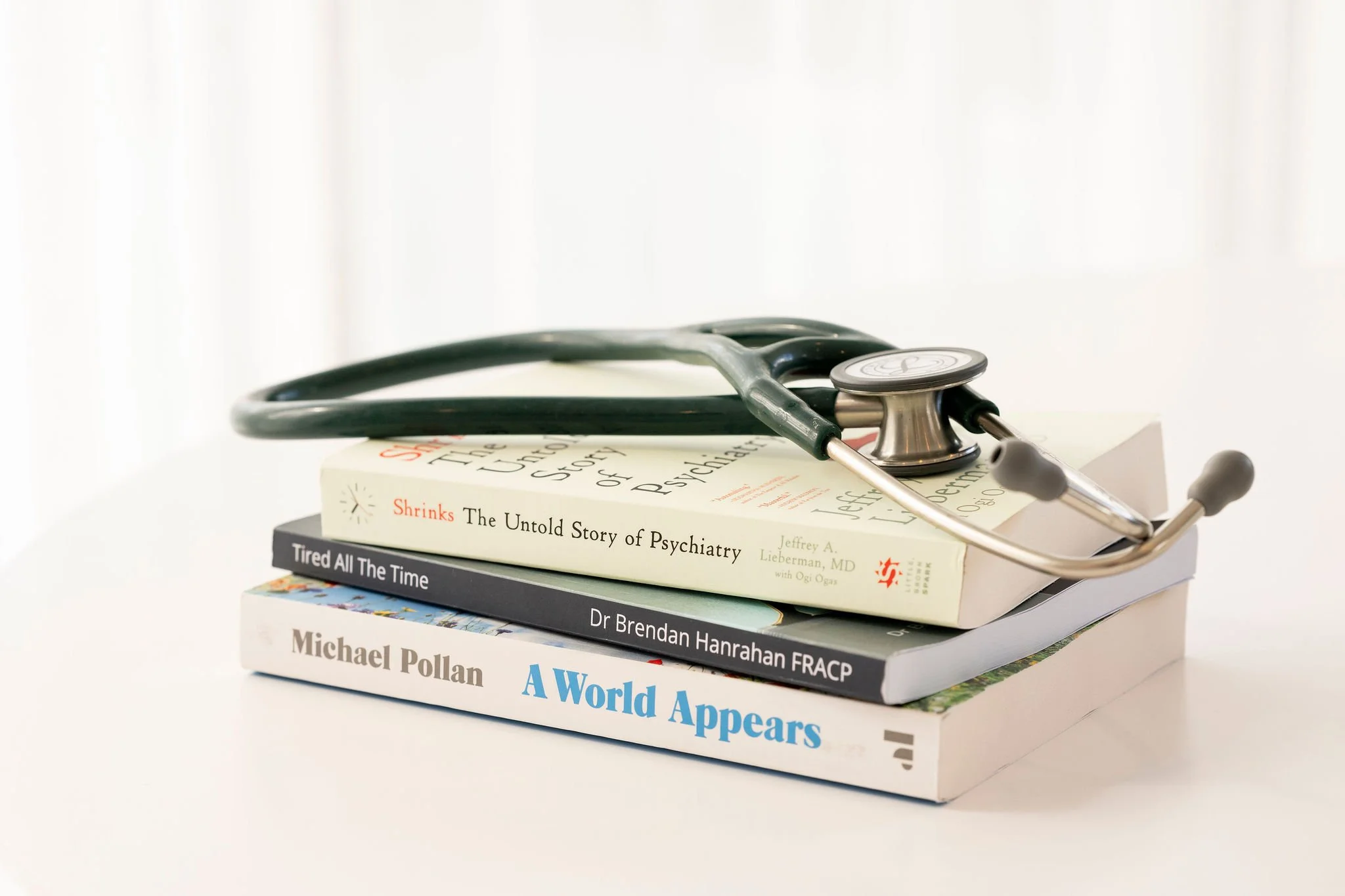 Stethoscope resting on a stack of medical books