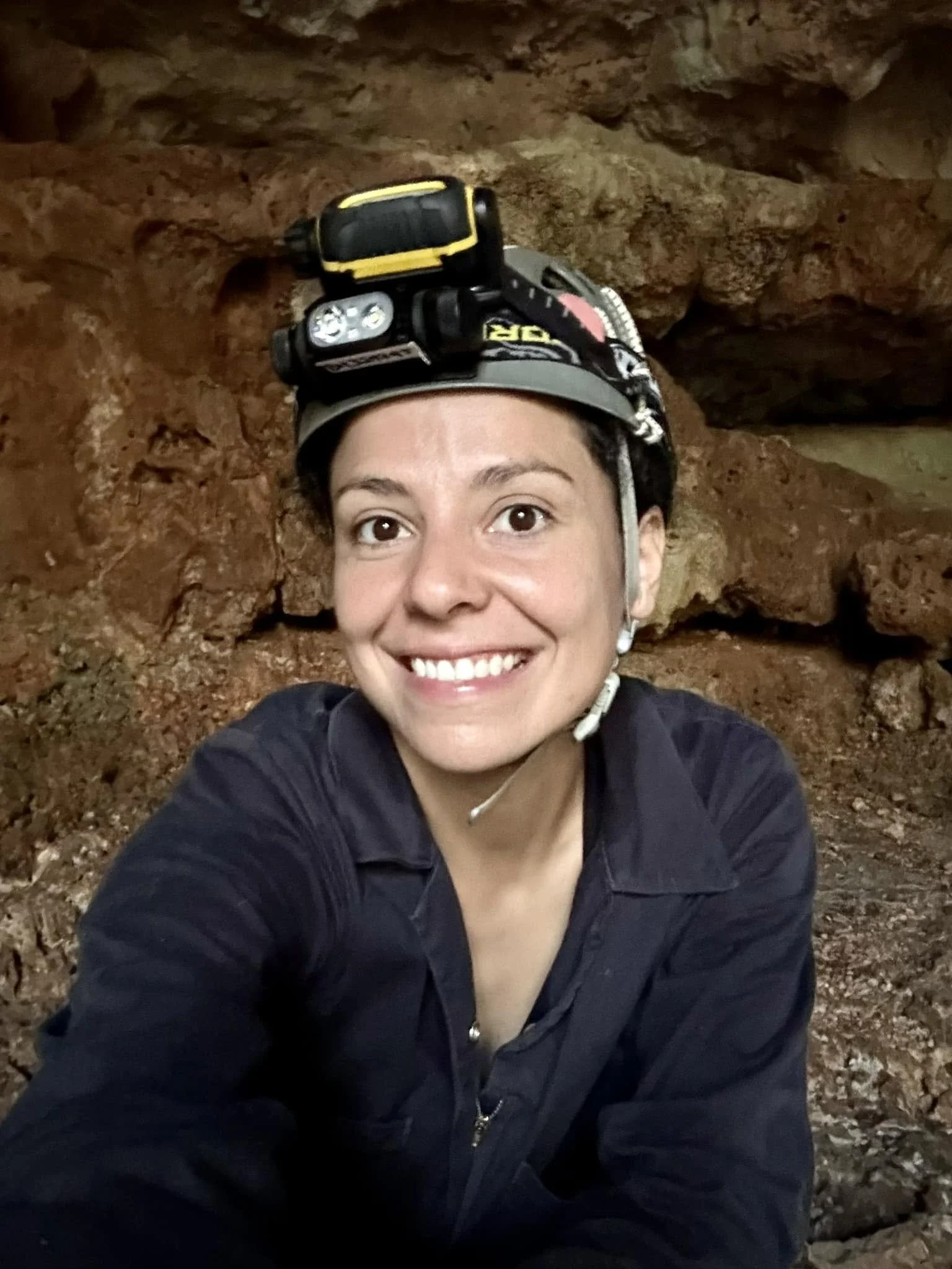 Cave diver and scientist Kay wearing a helmet and head lamps