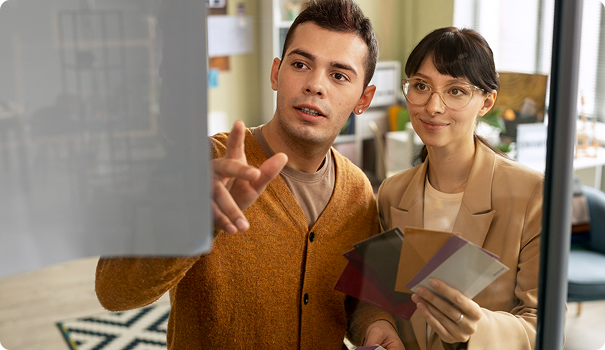 A man and a woman discussing color samples in an office.