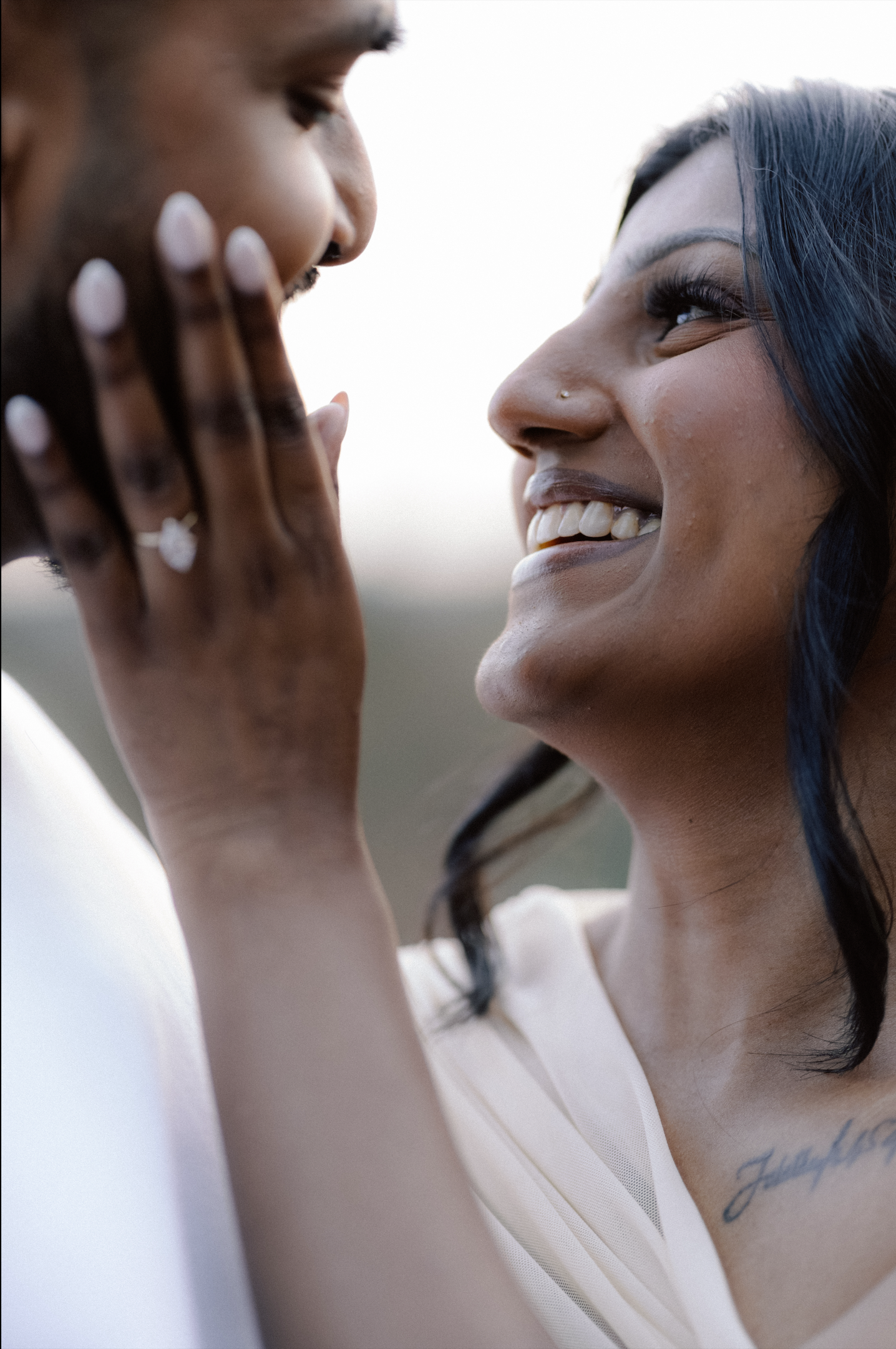 Close-up portrait of an Asian engagement couple sharing an intimate, romantic moment, smiling lovingly as they embrace.