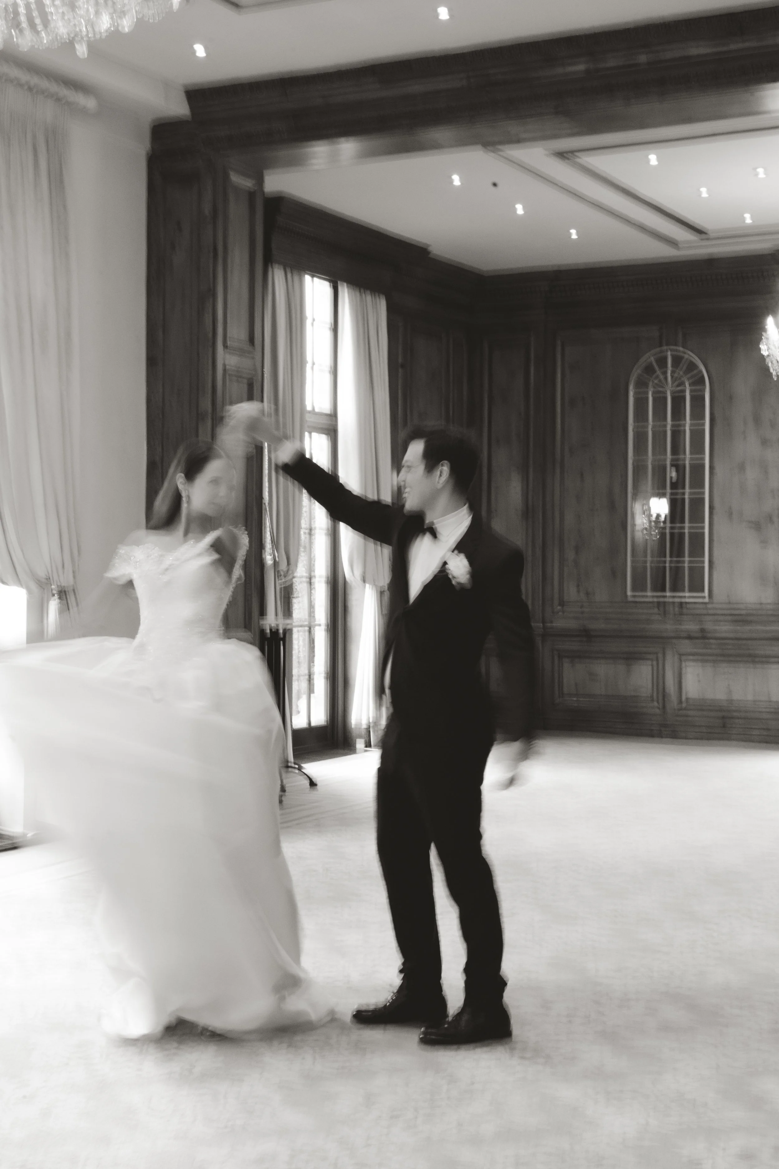 A romantic couple sharing their first dance in the grand, wood-paneled ballroom at Hedsor House, with the bride in a luxury wedding dress and the groom in a classic tuxedo.