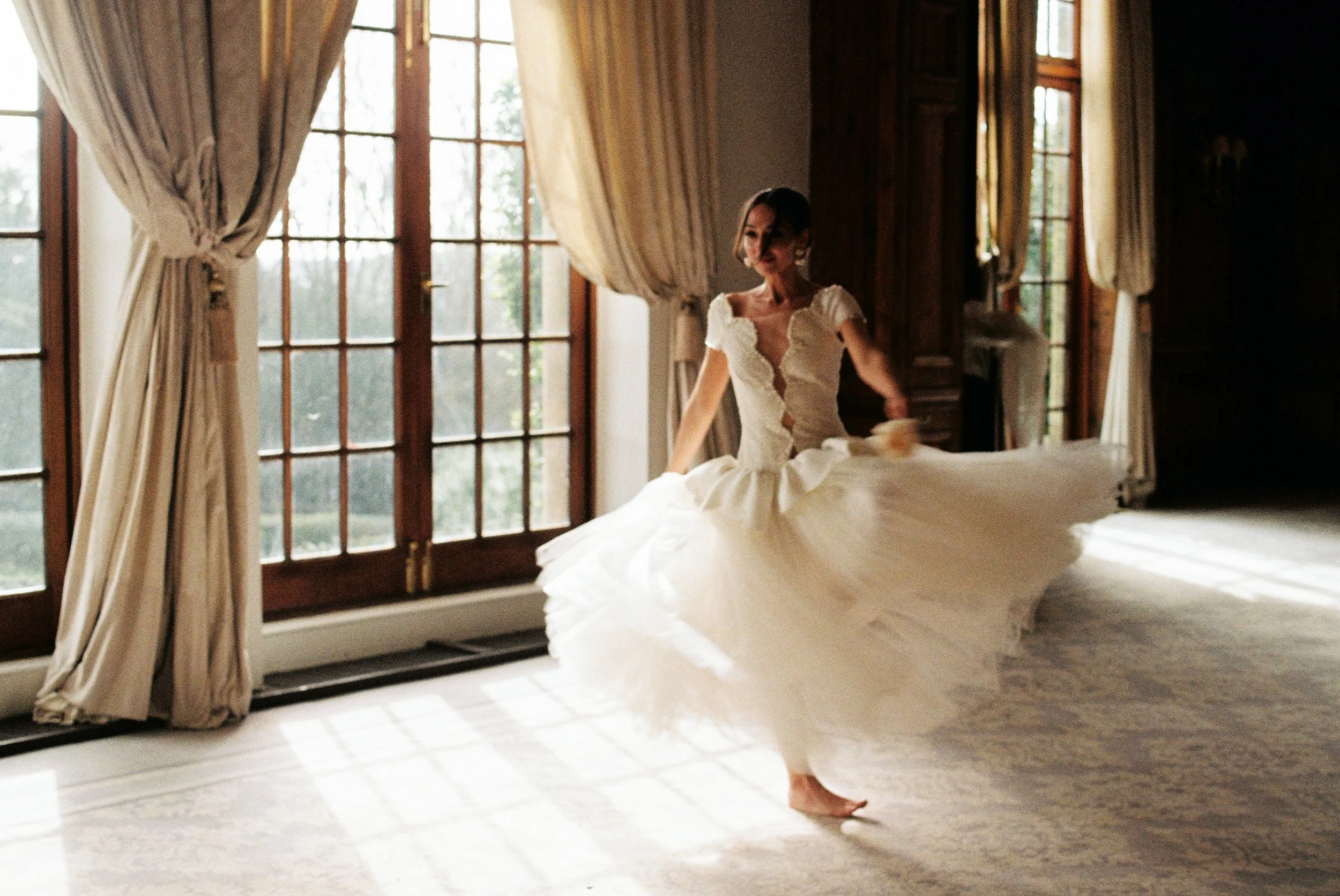Bride in a white gown dancing in the ballroom at Hedsor House.