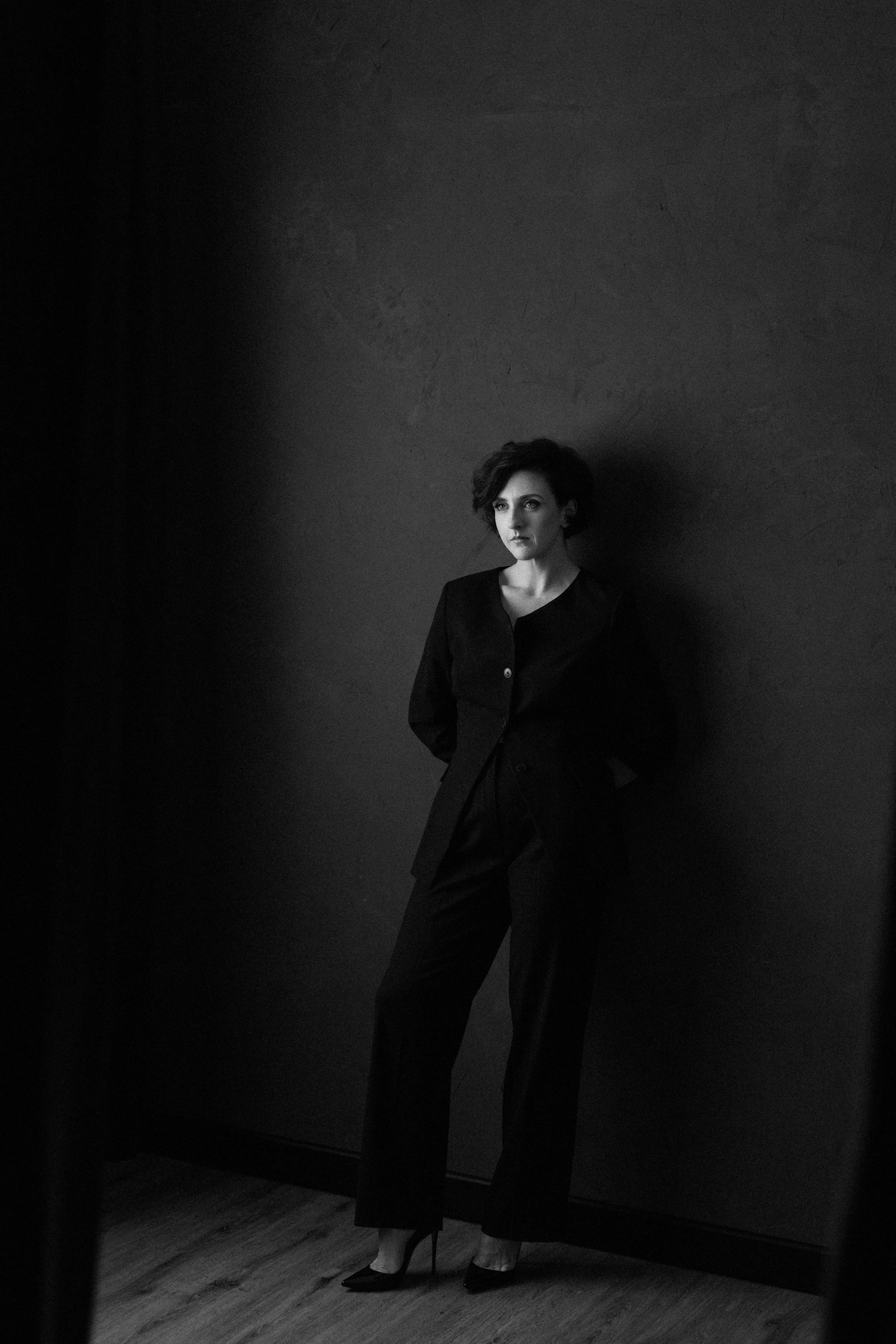 Jacs Batchelor in a black suit against a dark studio backdrop