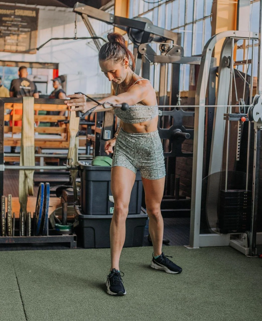 A woman working out in a gym using resistance bands for strength training.