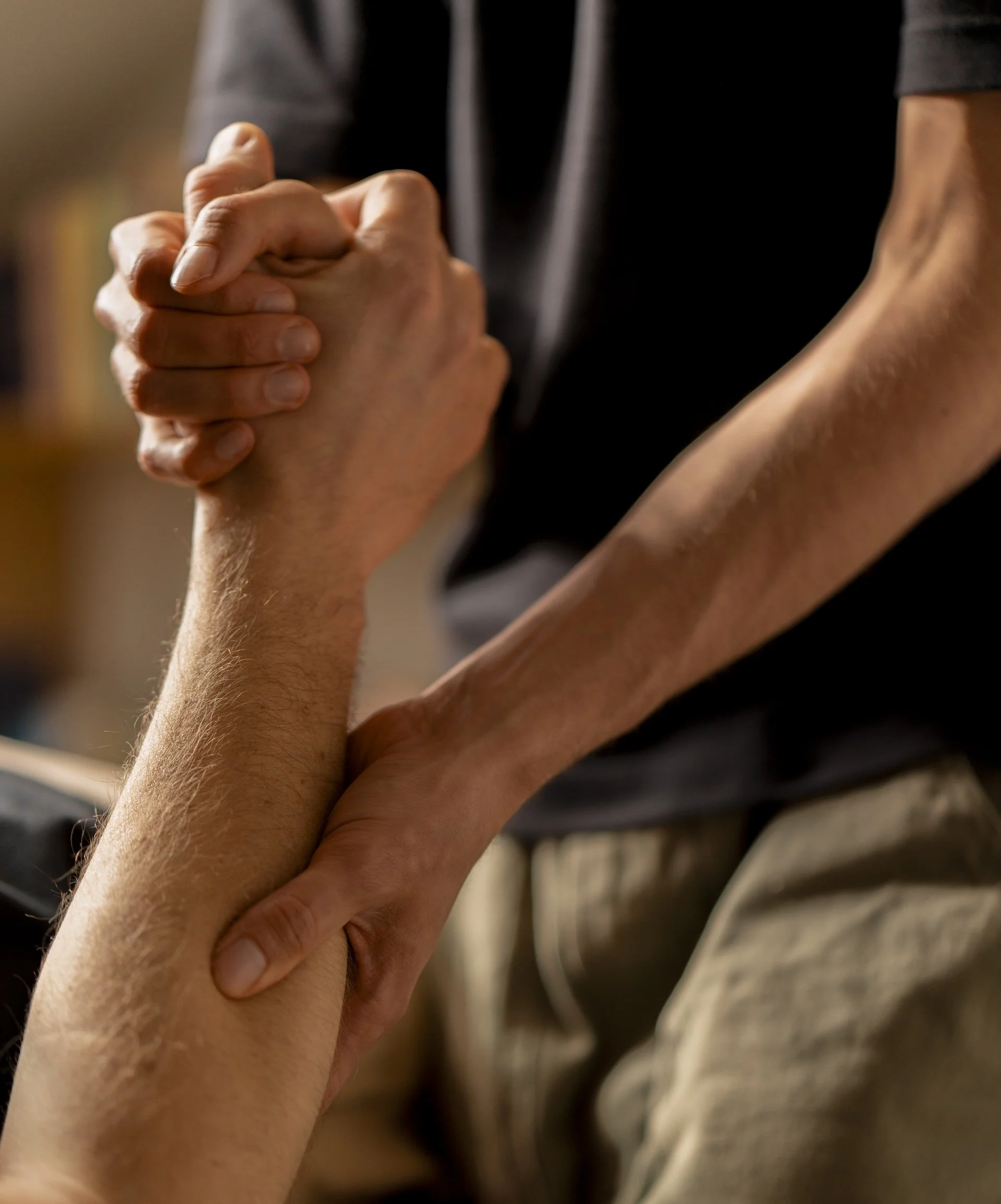 Deux mains qui s'agrippent fortement, une probablement d'un adulte et l'autre d'un enfant, dans une posture qui suggère le soutien ou la solidarité.