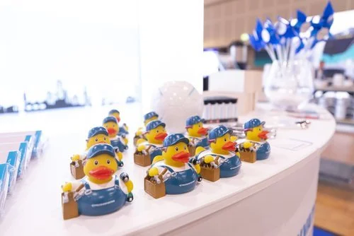 Mehrere gummibärchenförmige Figuren in Polizeiuniformen, die kleine Taschen und Helme tragen, auf einer Ladentheke platziert.