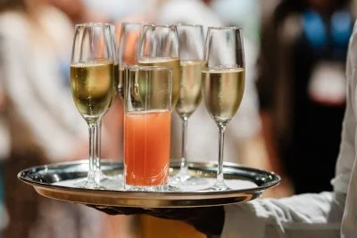 Sektgläser mit Sekt und ein Cocktail auf einer Silberplatte