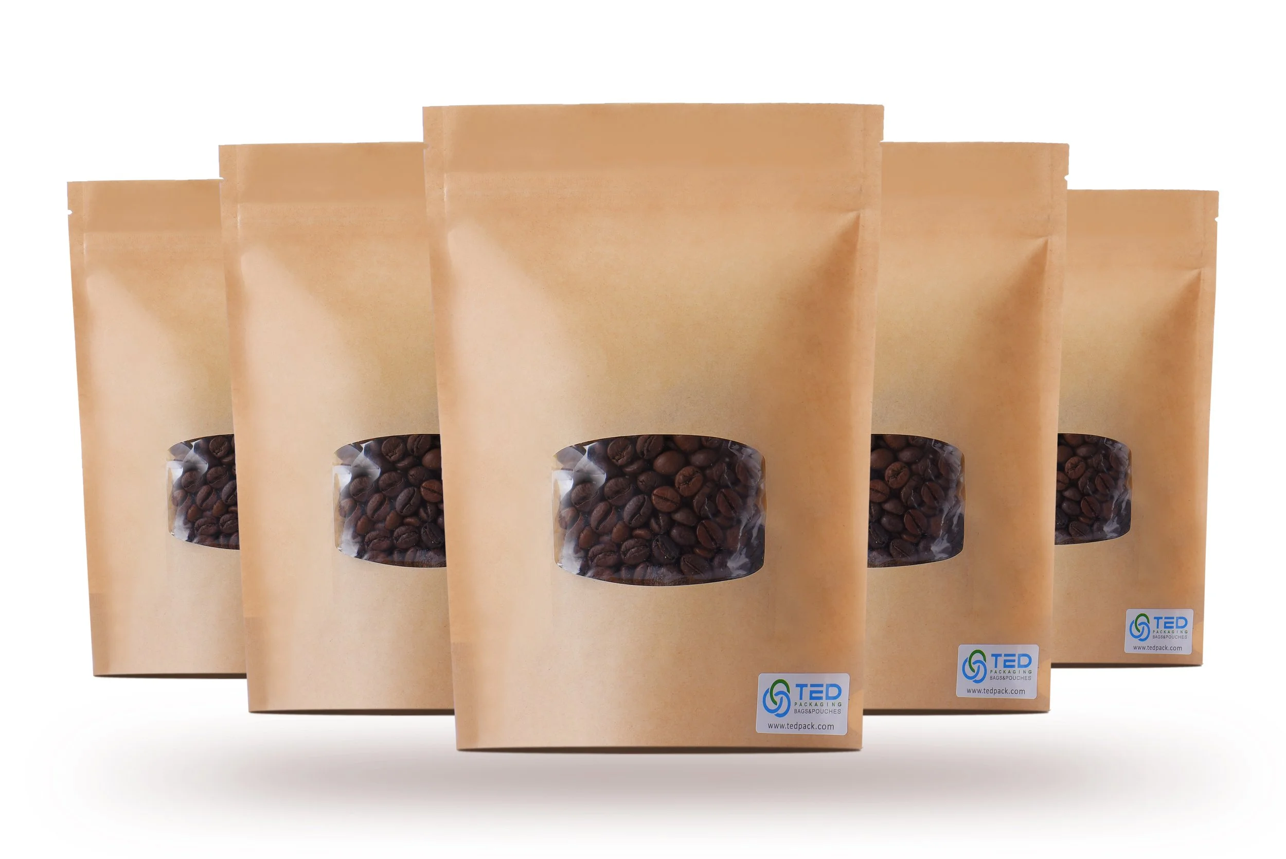 Multiple brown kraft paper stand-up pouches filled with coffee beans, displaying a clear window and a logo sticker at the bottom.