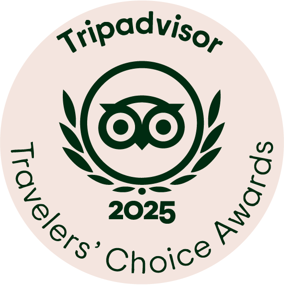 En rund logo for TripAdvisor med en ugle i midten, omgitt av laurbærgrener, med teksten "Tripadvisor 2025 Travelers' Choice Awards" rundt.