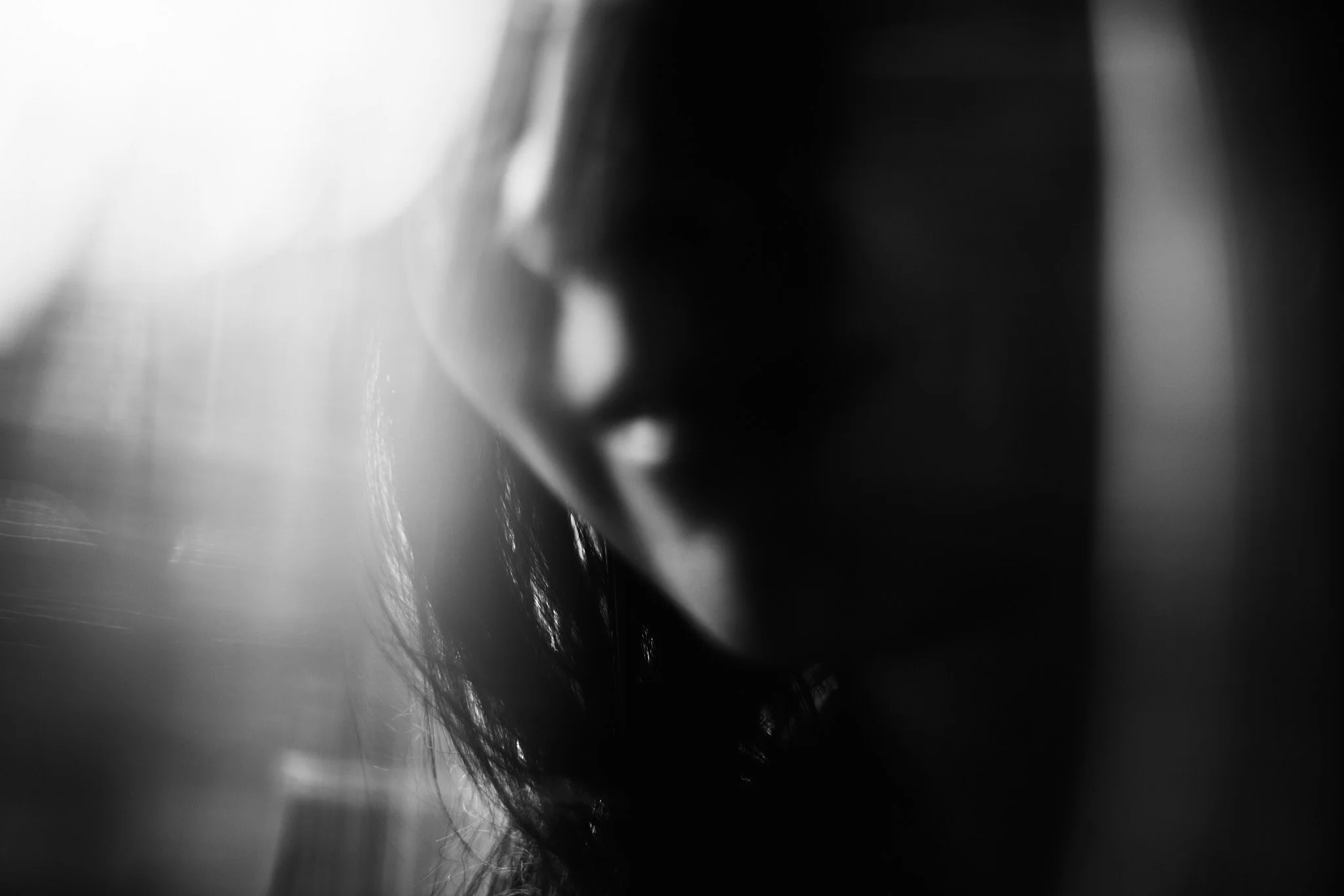Close-up portrait with most of the face softly out of focus, leaving only part of the features visible.