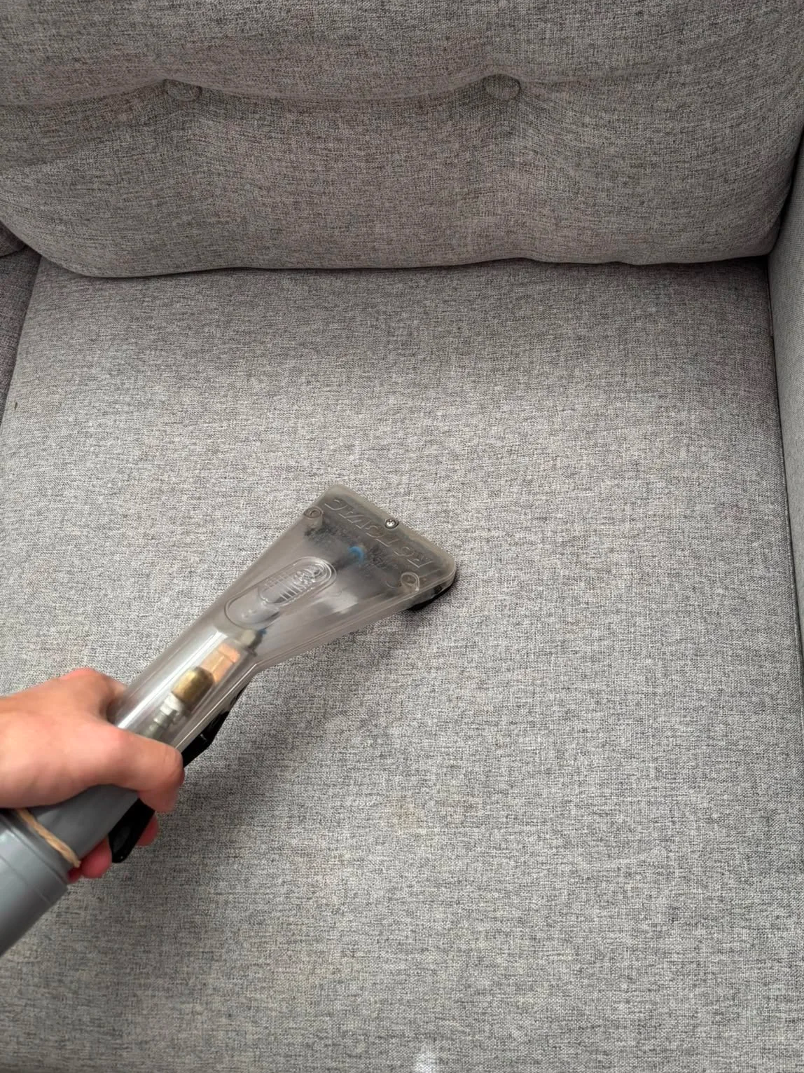Professional hot water extraction upholstery cleaning on a grey fabric sofa in South West London and Surrey.
