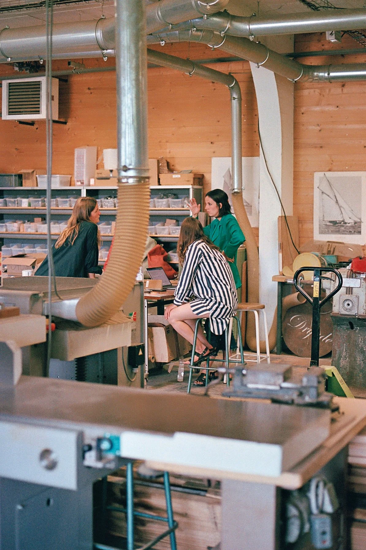 Atelier d'artisan Dryade, savoir-faire marins, entourées d'outils et d'équipements industriels, dans un environnement en bois et métal.