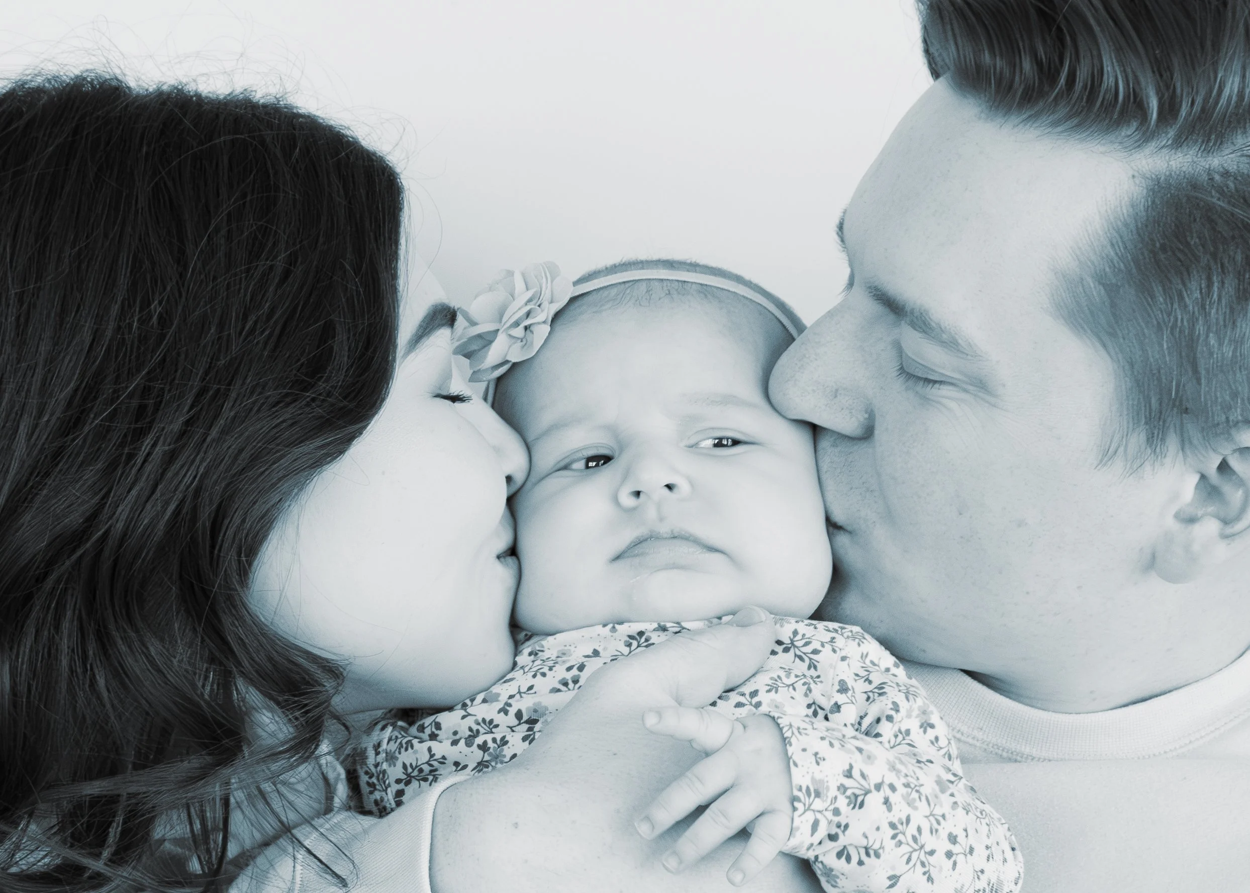 Family of four, including two children, close-up with faces touching, expressing love.
