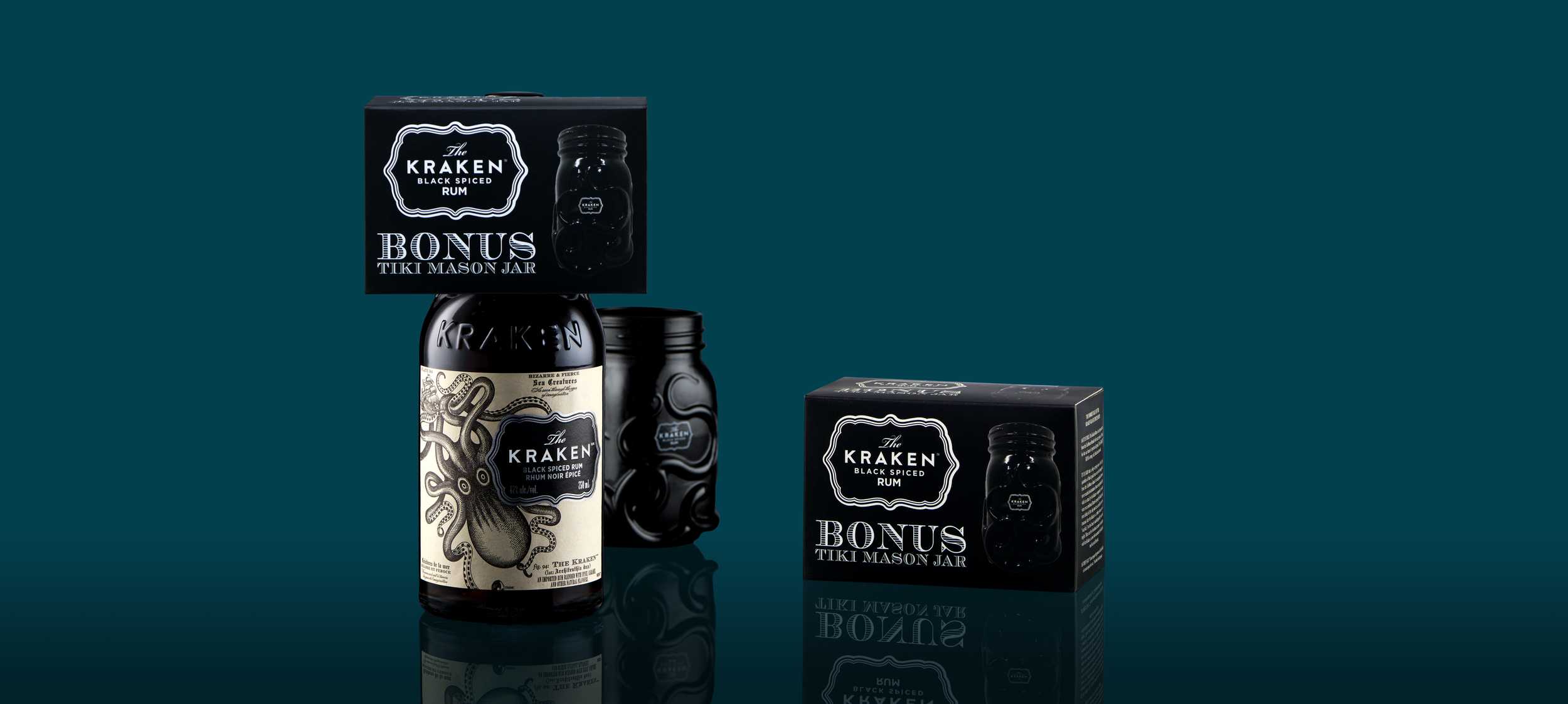 Set of Kraken black spiced rum bottles and packaging, including bonus tiki mason jar, on a teal background with reflections.