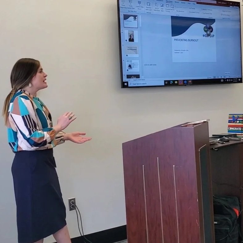 C.P. Handler giving a presentation in front of a large monitor in a conference room.