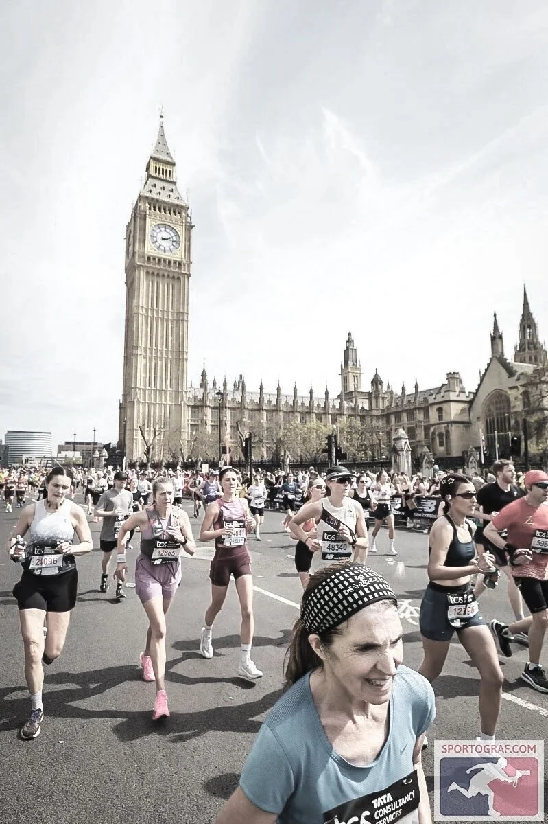Marathon runners participating in a race in front of Big Ben and the Houses of Parliament in London.