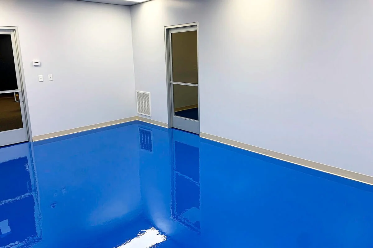 Empty room with white walls, blue shiny floor, and two glass doors.