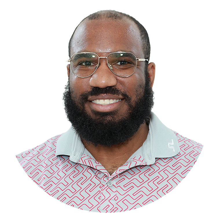 A man with short cut black hair smiling, with glasses on.
