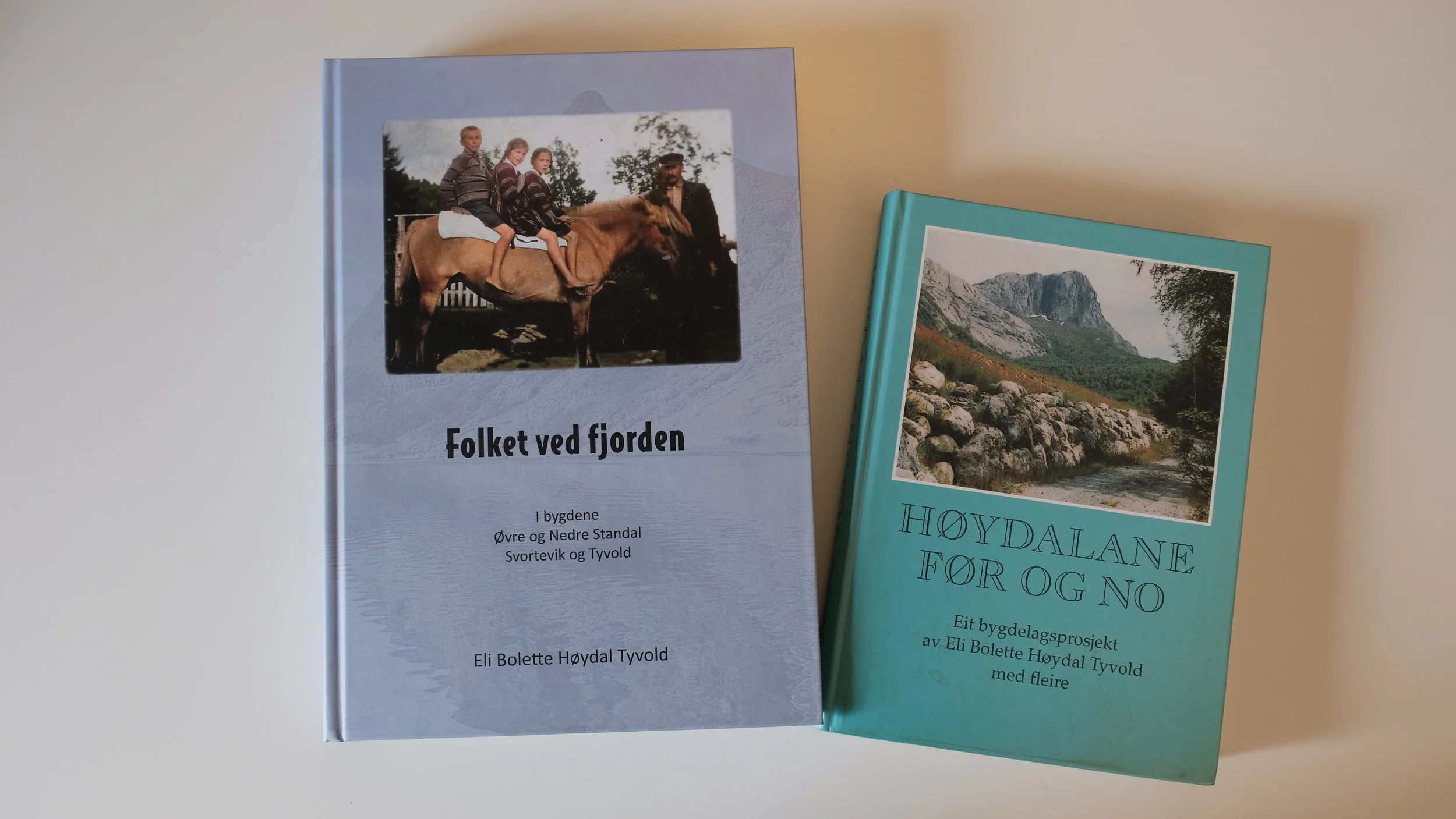 Bilde av to bøker. Den ene boken har to gutter og ei jente på hesteryggen, mens den andre viser en fjellandskap med trær og steiner. Tekst på bøkene er på norsk.