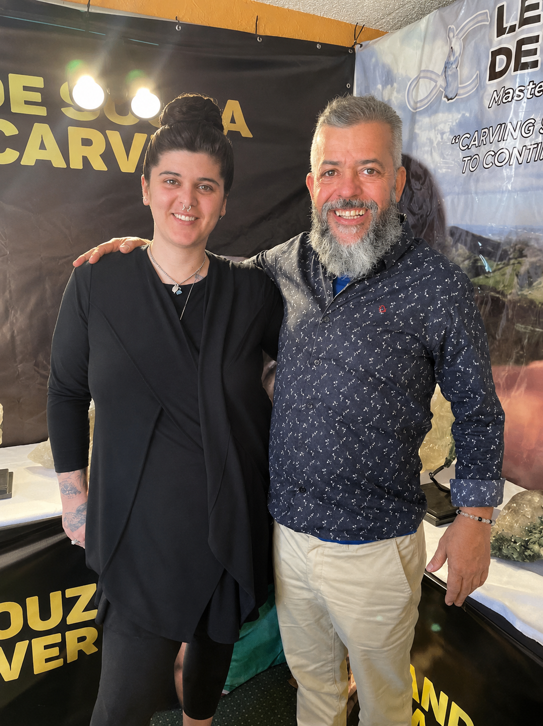 Leandro de Souza and Caitlin of All My Skulls standing together at Leandro's booth at the 2023 Tucson Gem Show.