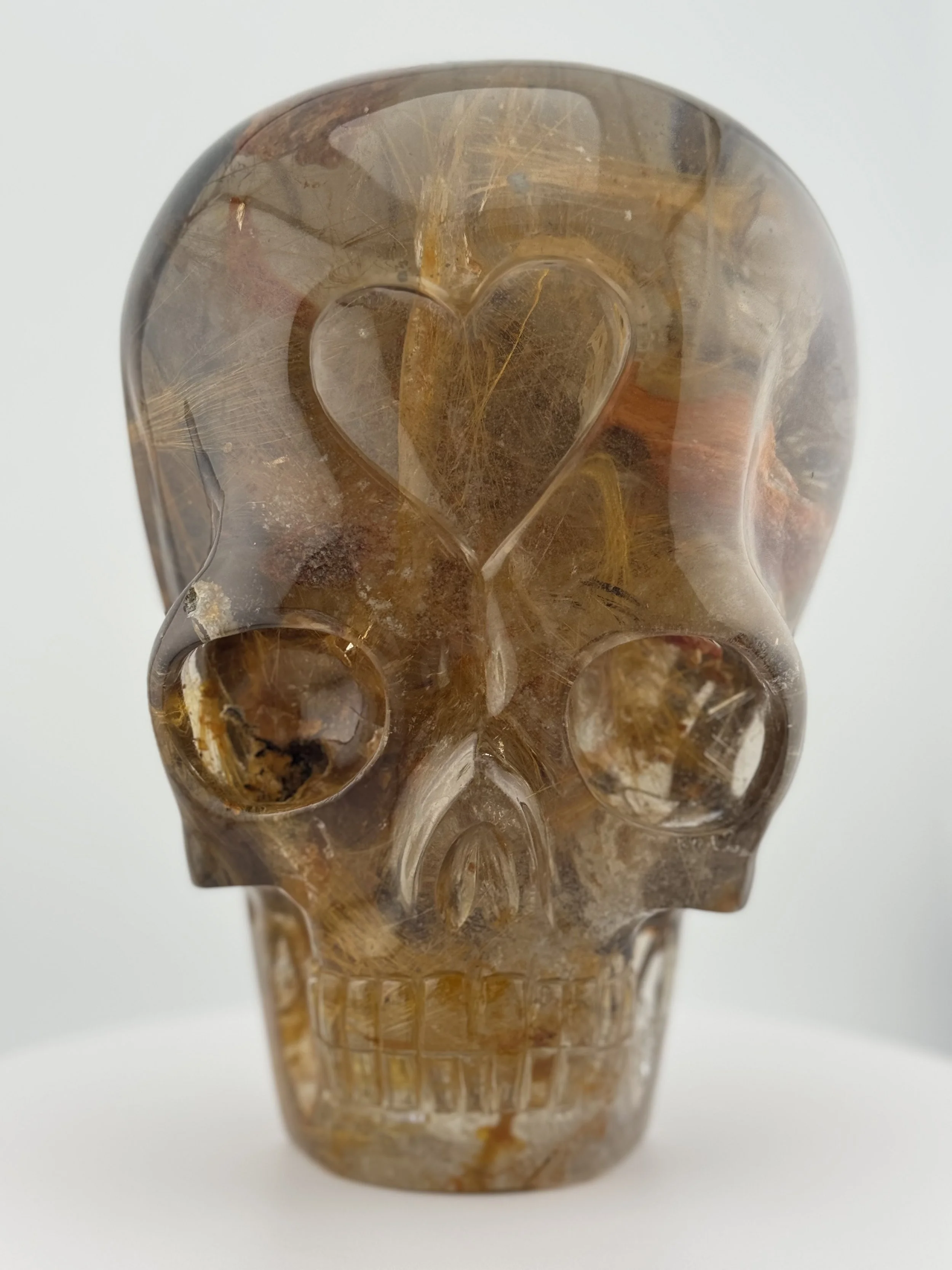 Marygold Rutile Shaman Skull called Jerusalem, with a heart-shaped indentation in the center of the forehead, carved by Leandro de Souza in 2024.