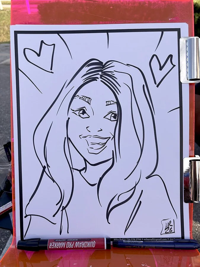 A black marker sketch of a smiling woman with long hair, outlined with cartoon-style line art, on a whiteboard with hearts around her. A marker labeled "QUICKDRAW PRO MARKER" rests at the bottom of the whiteboard.