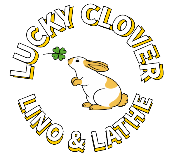 A cartoon illustration of a jumping rabbit with a green four-leaf clover, surrounded by the text 'Lucky Clover Lining & Lathe' in yellow and white letters forming a circle.