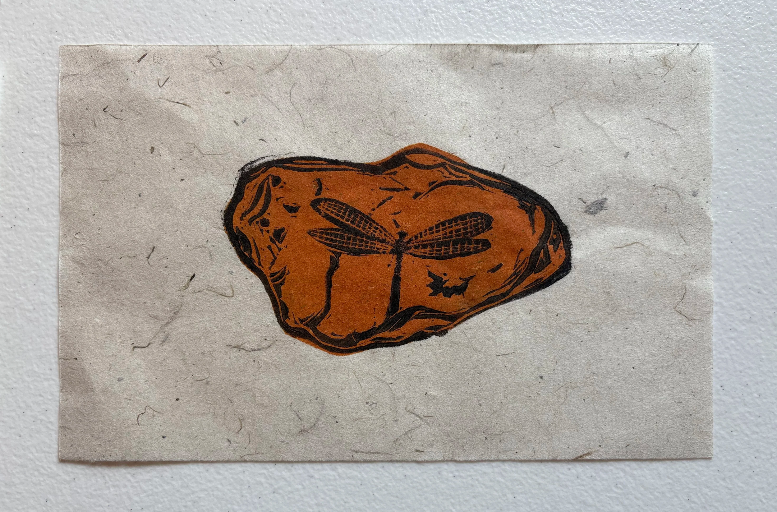 Drawing of a brown potato with a black outline and a small dragonfly in black on its surface, on a textured paper background.