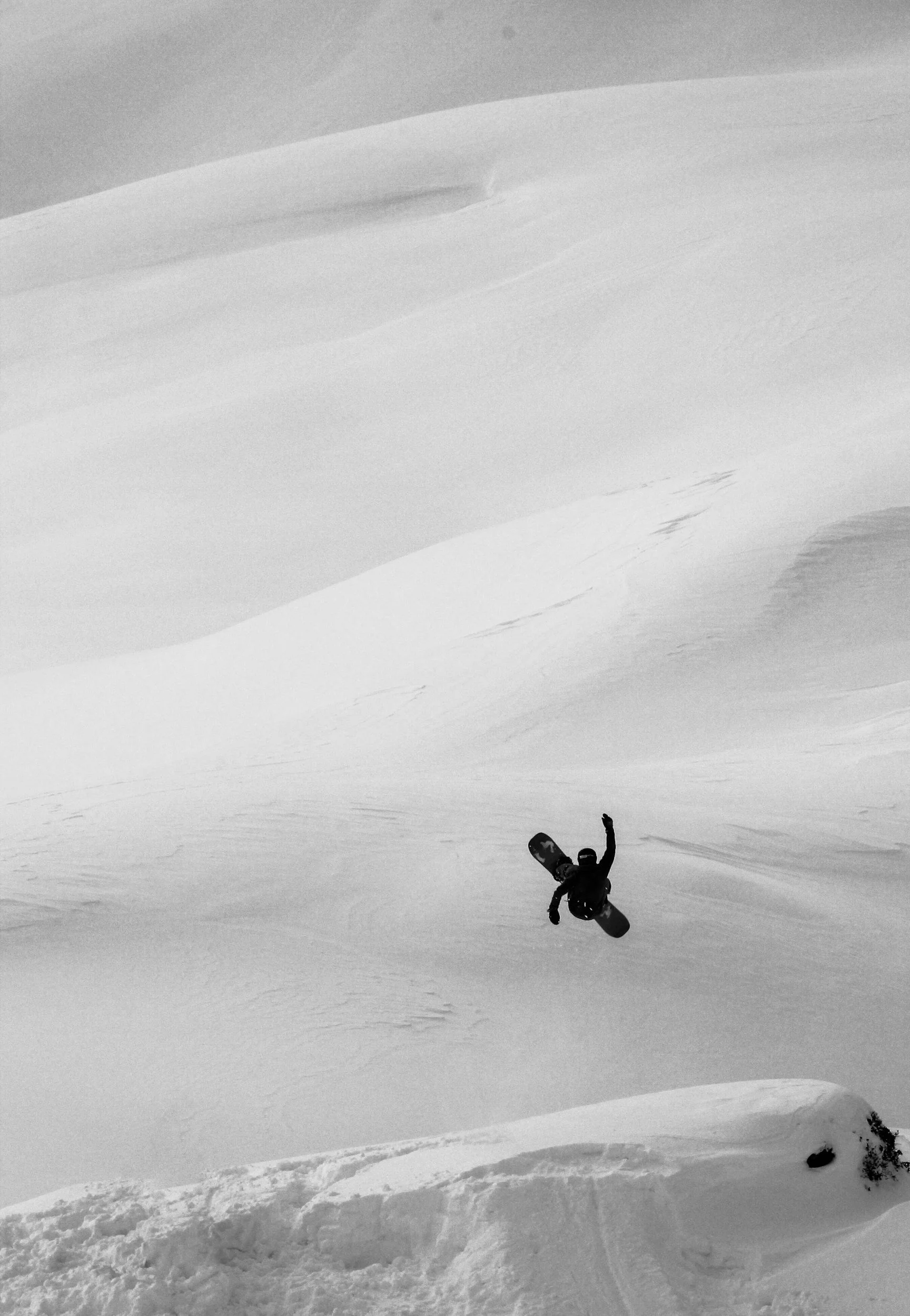 Snowboarder jumping in a snow-covered mountain landscape