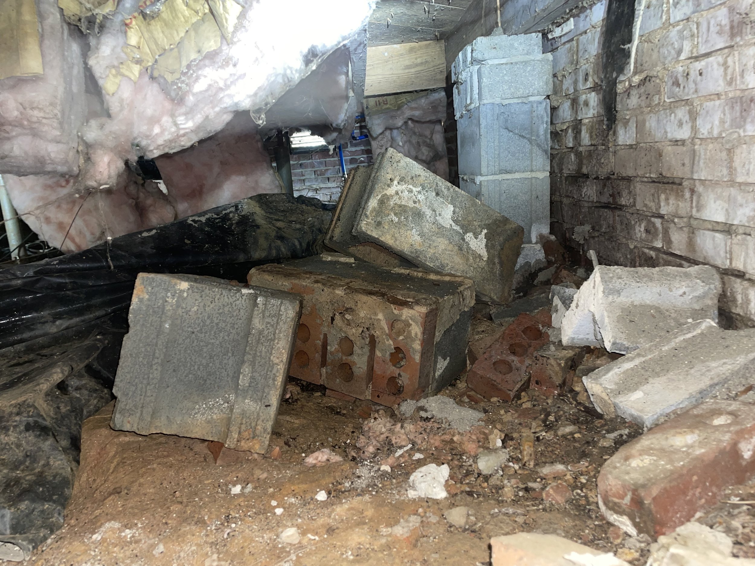 Davidson crawl space with construction debris, fallen insulation, exposed soil and damaged vapor barrier