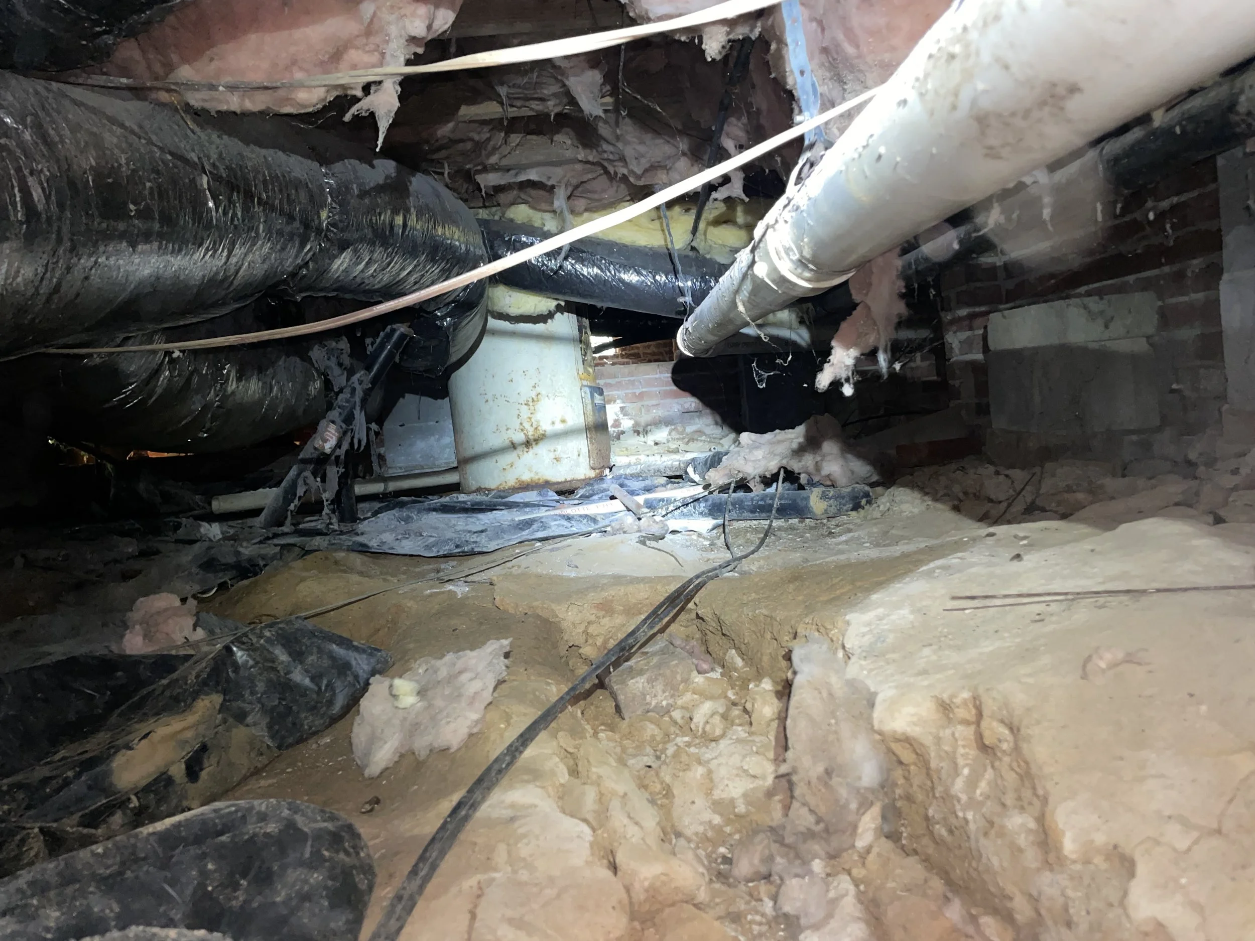 Sherrills Ford crawl space with fallen insulation, damaged vapor barrier, exposed soil, debris and HVAC ductwork