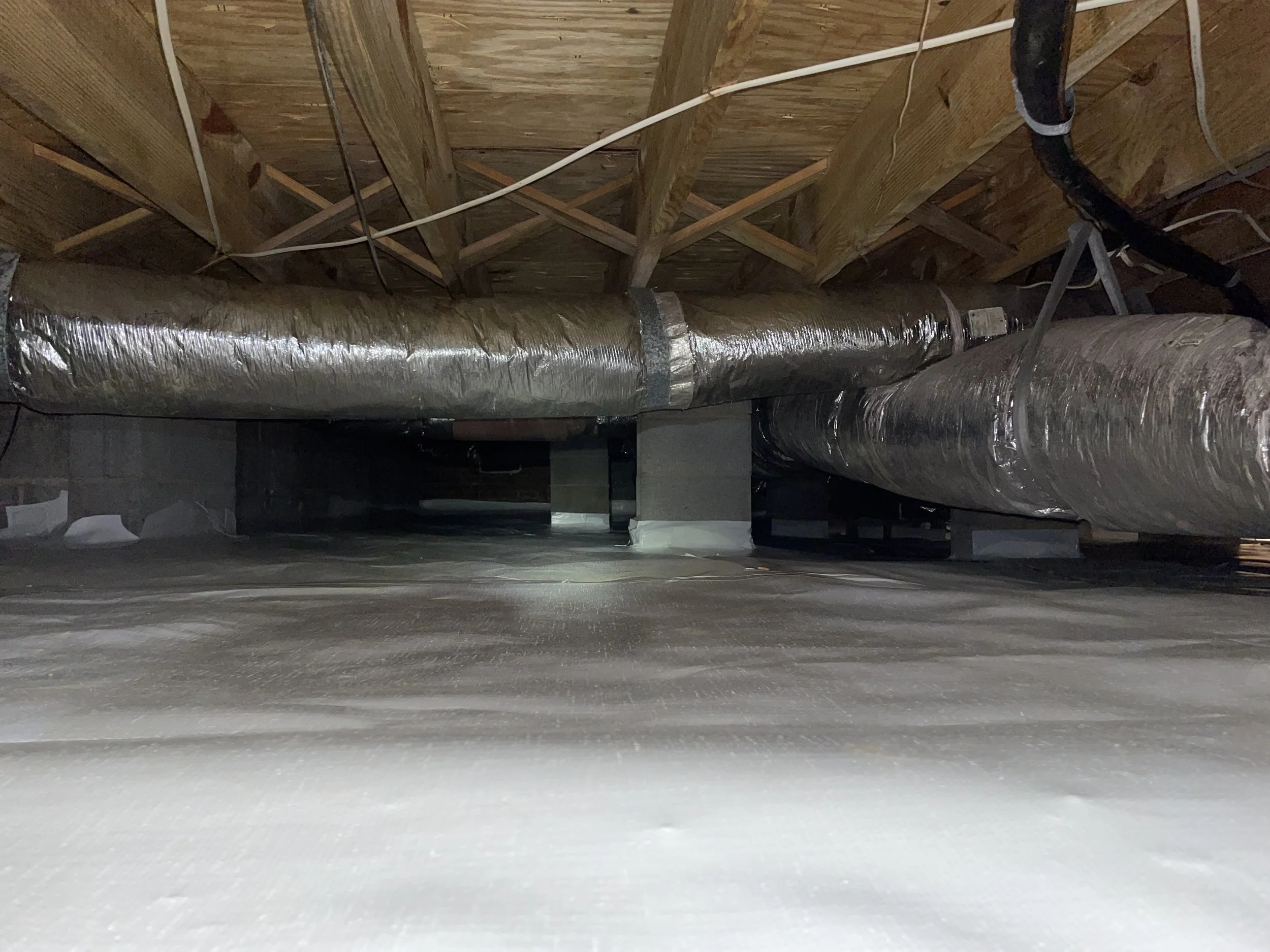 Starter crawl space encapsulation with sealed ground liner after insulation removal and mold treatment beneath the home