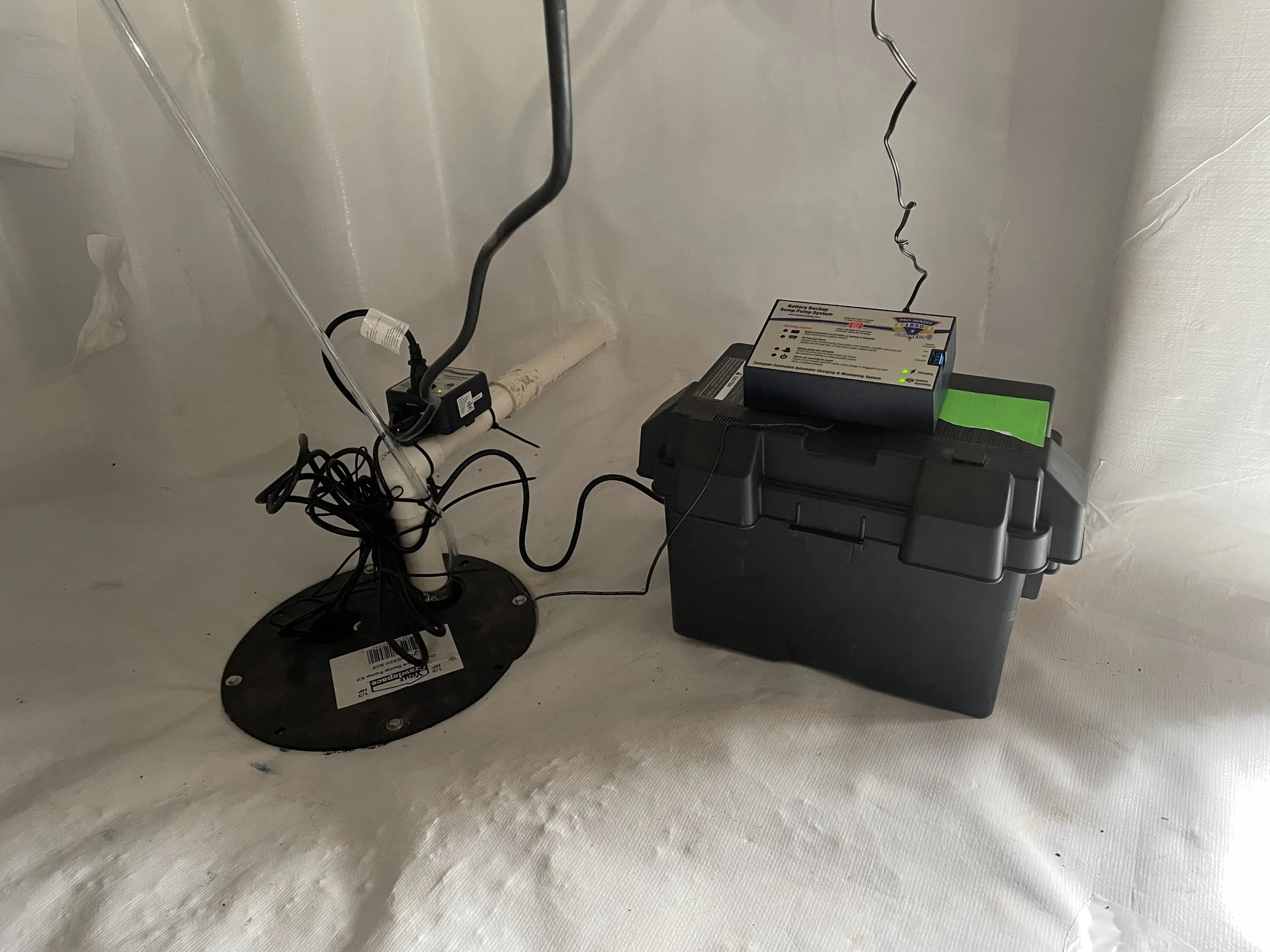 Crawl space sump pump with battery backup installed inside an encapsulated crawl space.