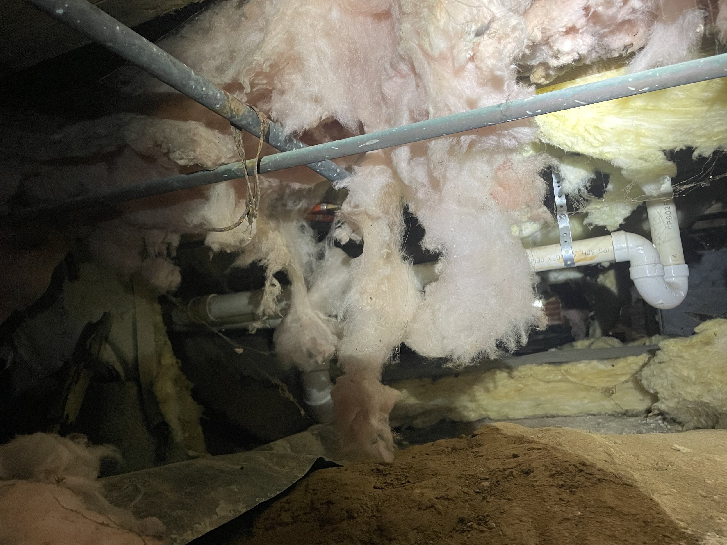 Charlotte crawl space with wet, sagging insulation, exposed soil and damaged moisture protection