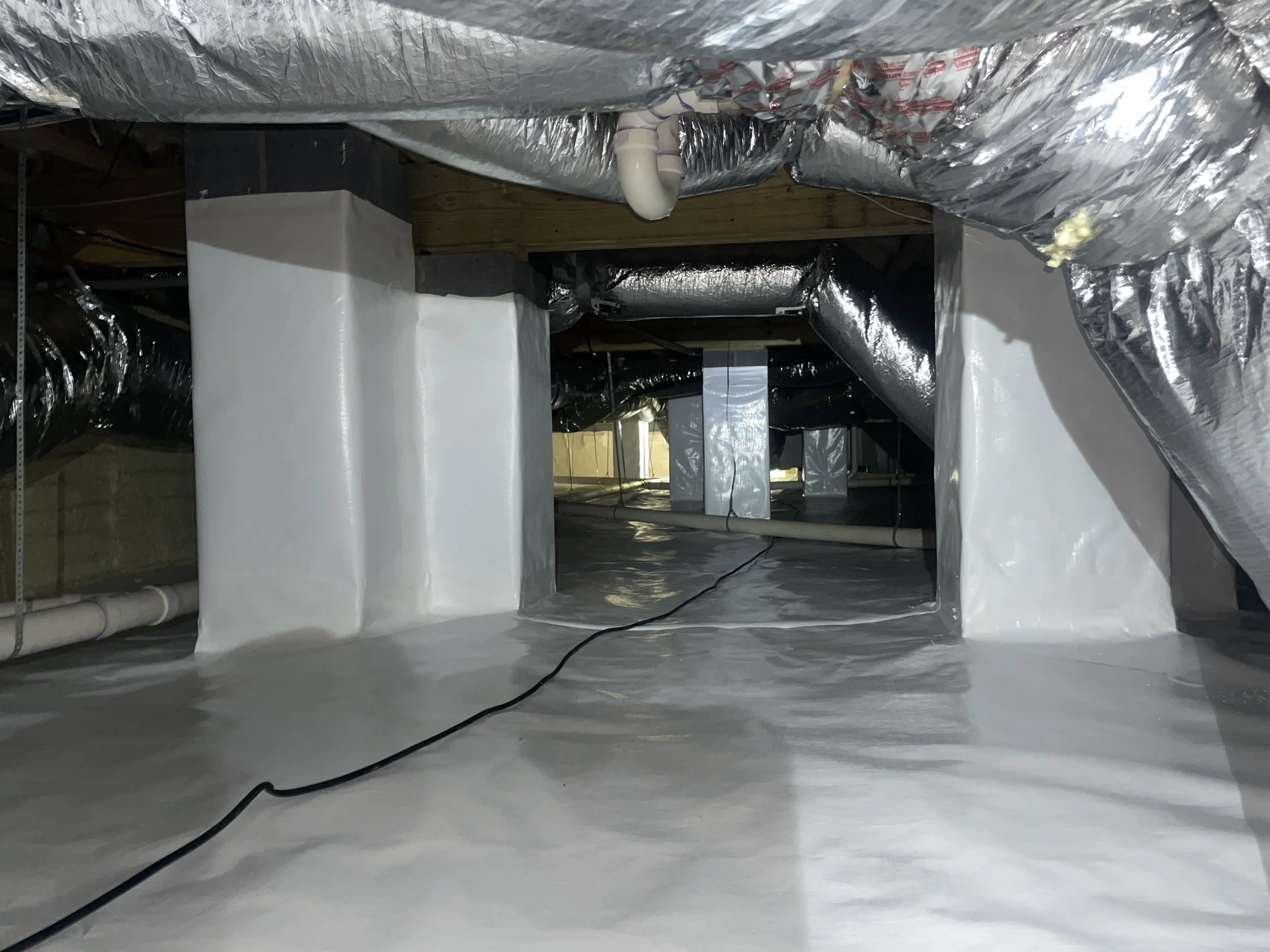 Full crawl space encapsulation in Davidson with a sealed floor liner, wrapped piers and exposed wood framing