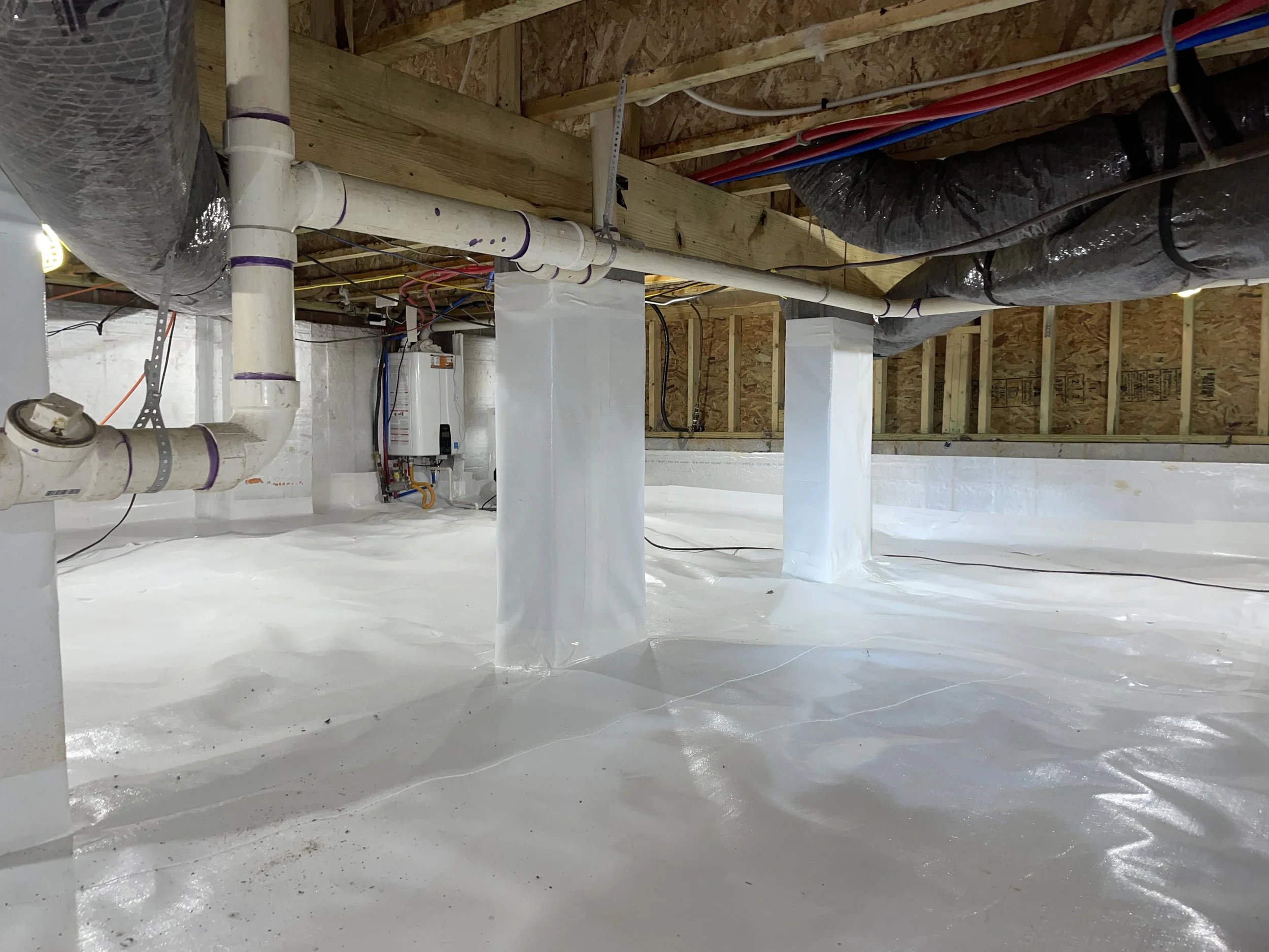 Full crawl space encapsulation in Charlotte with a sealed floor liner and wrapped piers