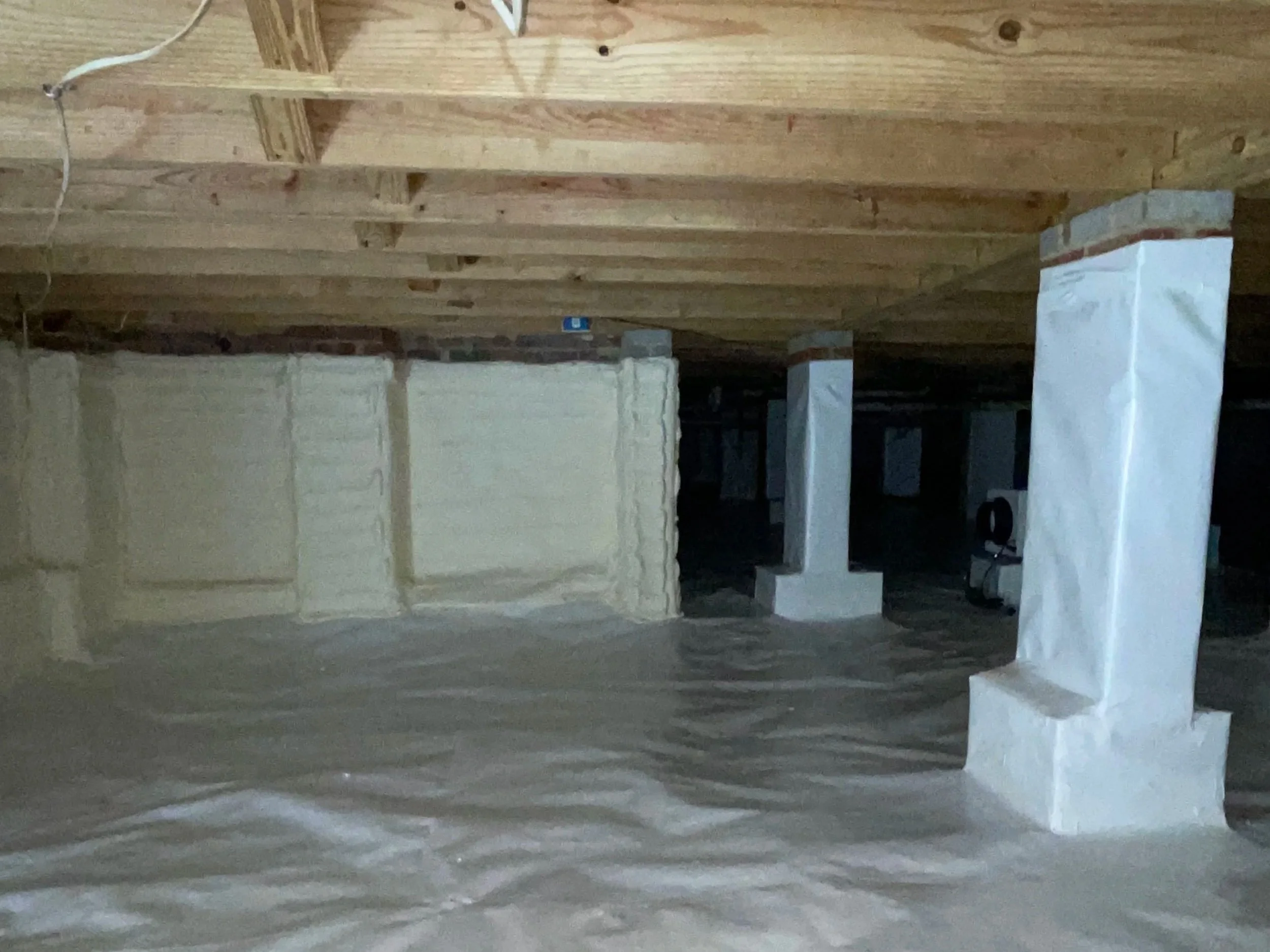 Full crawl space encapsulation in Denver, NC with a sealed floor liner, wrapped piers and spray foam foundation wall insulation