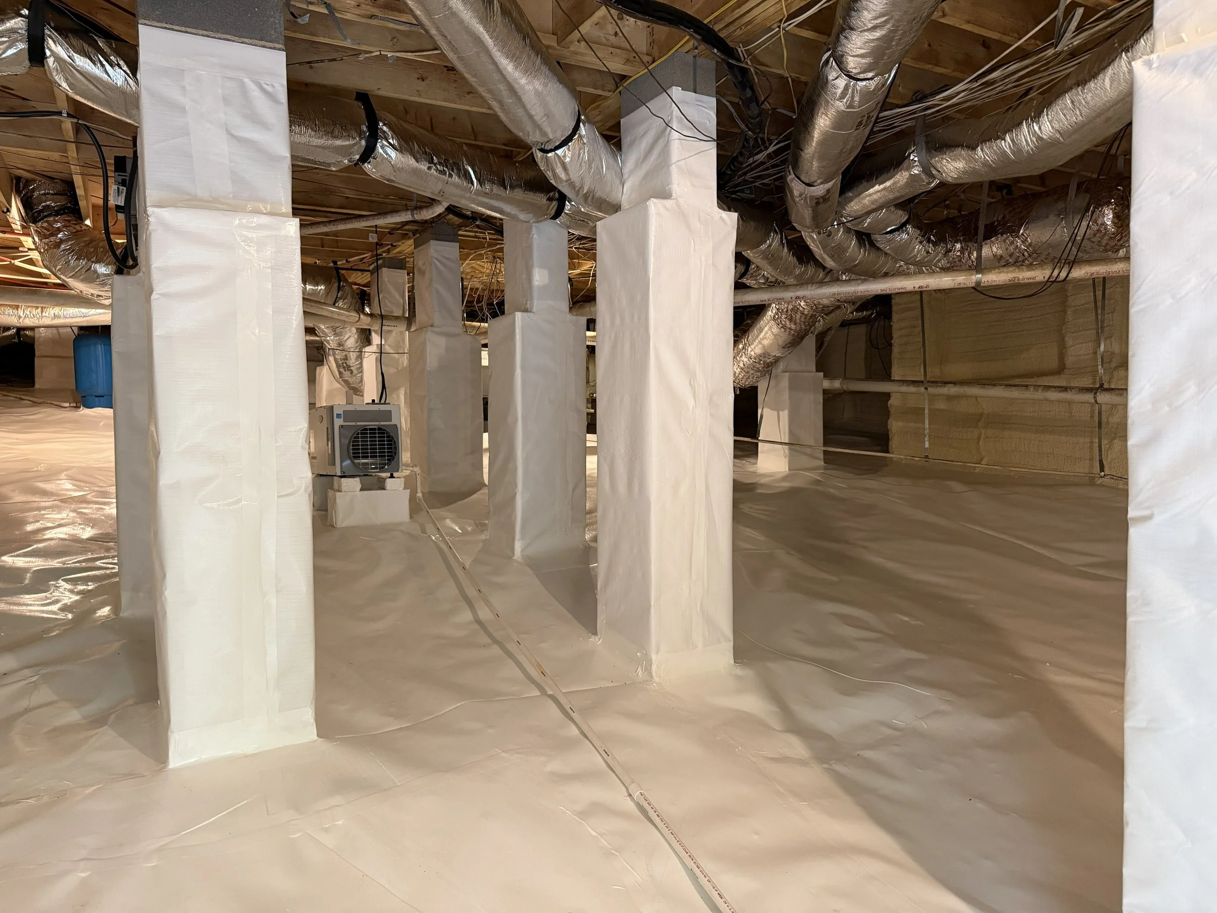 Fully encapsulated crawl space with new vapor barrier, dehumidifier and spray foam insulation.