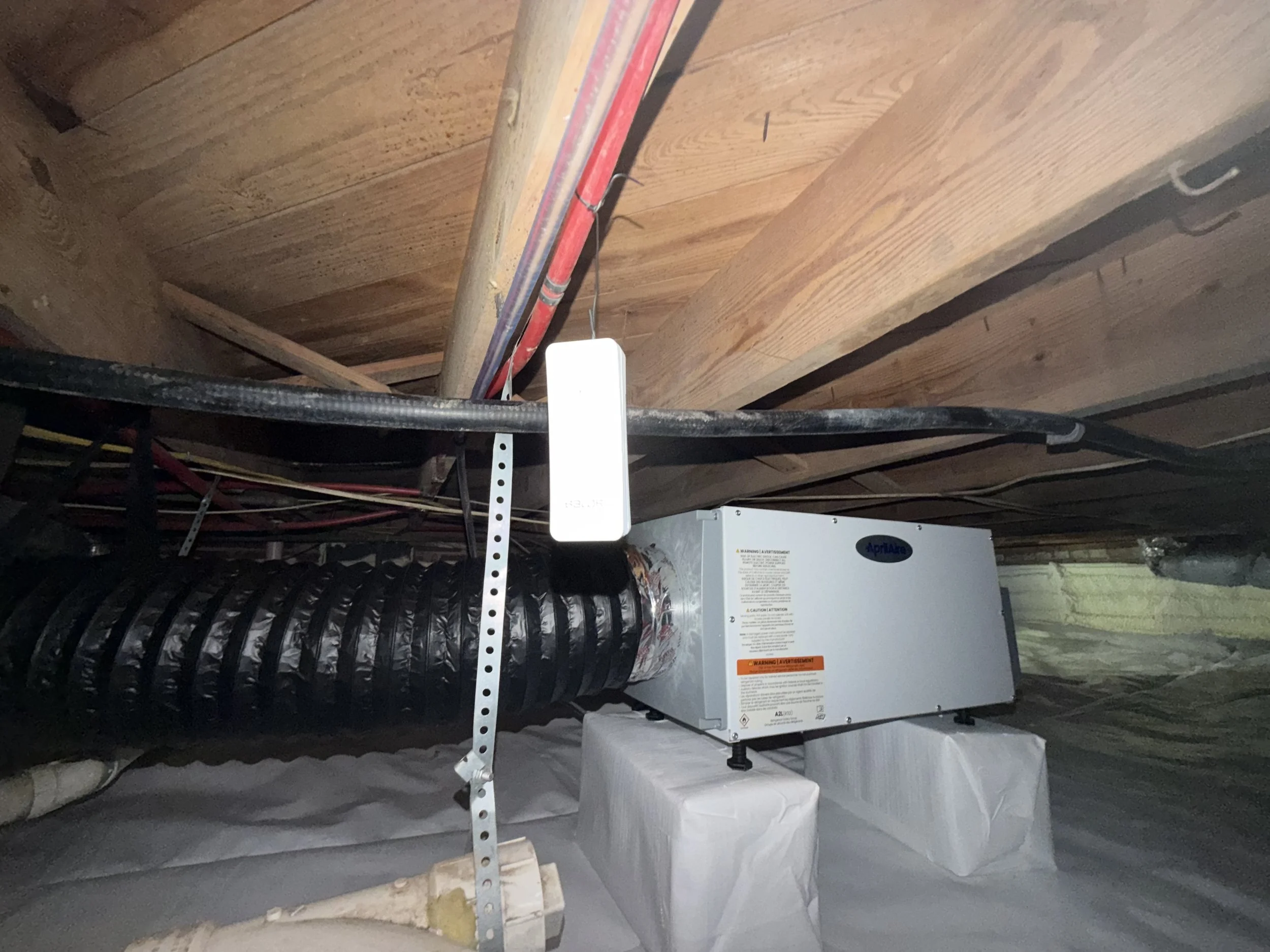 AprilAire® dehumidifier with a duct kit for extra airflow, installed to control moisture and help keep mold from returning. The floor joists remain exposed so dehumidified air can reach and protect the entire floor system.