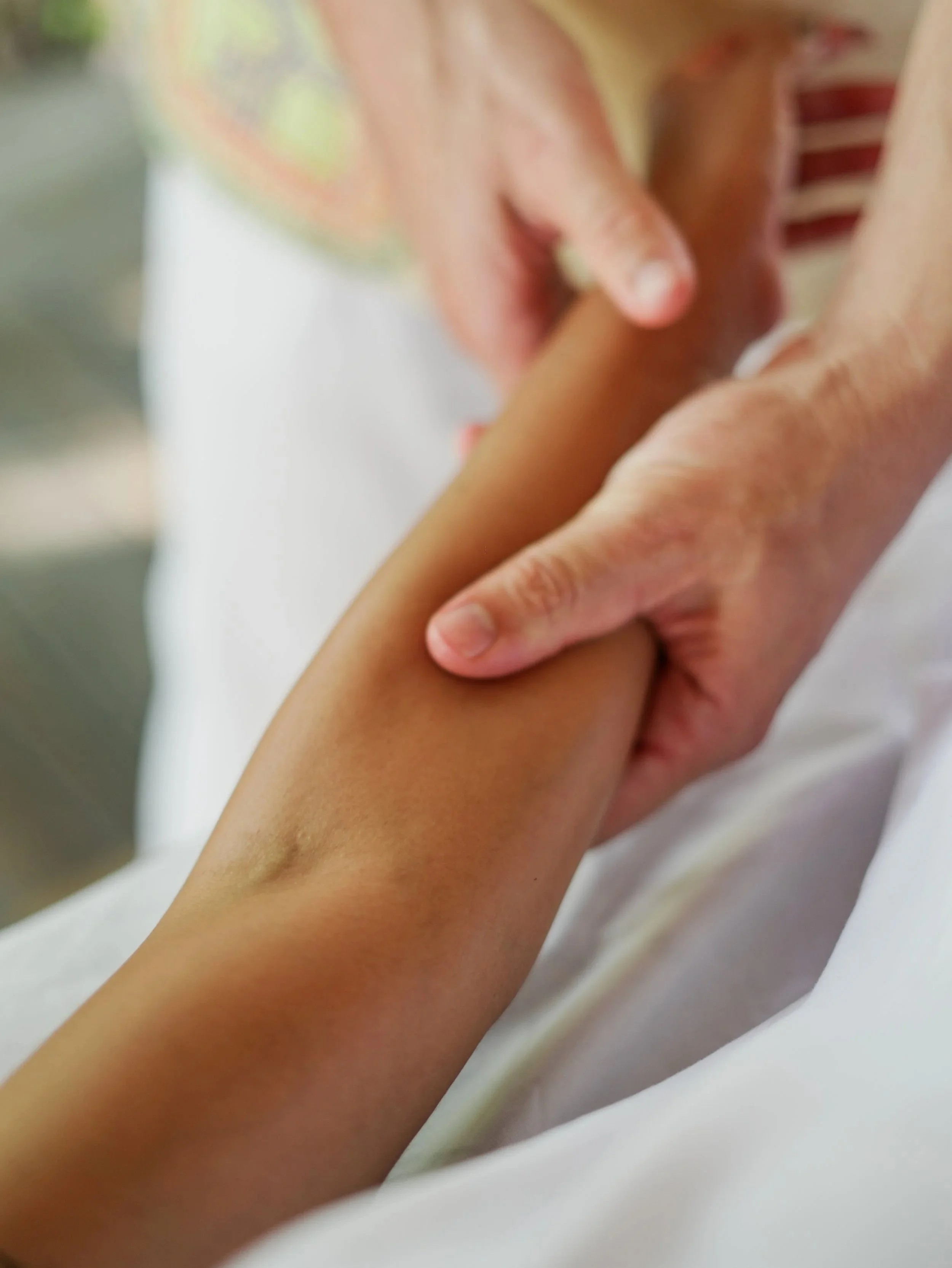 Nahaufnahme zweier Hände, die einen Unterarm mit Massageöl während einer Wellnessmassage bei Shipibo Massage Osnabrück massieren.
