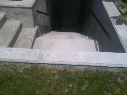 Concrete stairs installation leading down to basement entrance